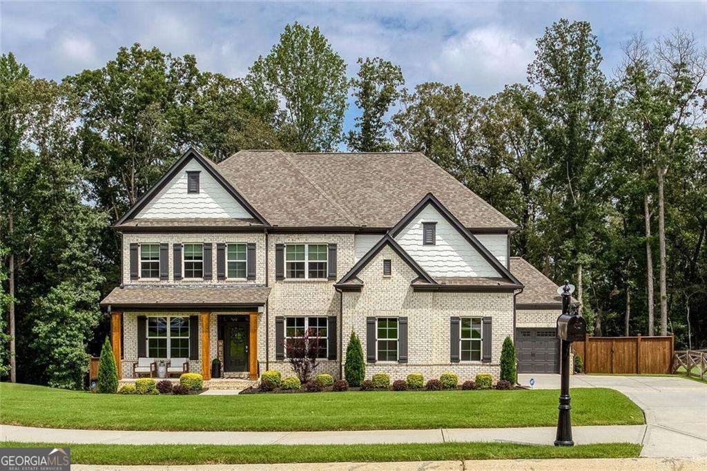 Welcome to this stunning 6,449 square foot brick-front cul-de-sac home with 3-car garage in Hoschton, GA featuring dramatic 6x9 windows, trey and coffered ceilings, and extensive upgrades throughout. The main level offers a chef's kitchen with granite island, custom pantry, wood beams in the keeping room, and cedar columns accenting the front porch, a guest bedroom with a full bath, a powder room, an office with french doors, a separate dining room with butler pantry, while the upper level boasts a spa-like master suite with walk in shower, walk in custom closet and extra sitting area in the master suite, also upstairs is a raised level video/theater/party room, a jack and jill suite with 2 bedrooms and an additional bedroom with its own bath and a large laundry with cabinets and sink in the hallway. The newly finished basement (2025) includes a custom home theater with a Murphy-Style hidden door and theater-styled leather seating, a full kitchen with flat-top, microwave/convection oven (air fryer) and refrigerator, dish washer, chiller, a bar area, a gym room, wine room, game room, and luxury steam shower, 2 rooms near the full bath could be bedrooms. A private fenced yard with a covered and screened rear porch, hardwood flooring throughout, custom cabinetry, and a professionally installed Tesla charger in the garage complete this one-of-a-kind home.