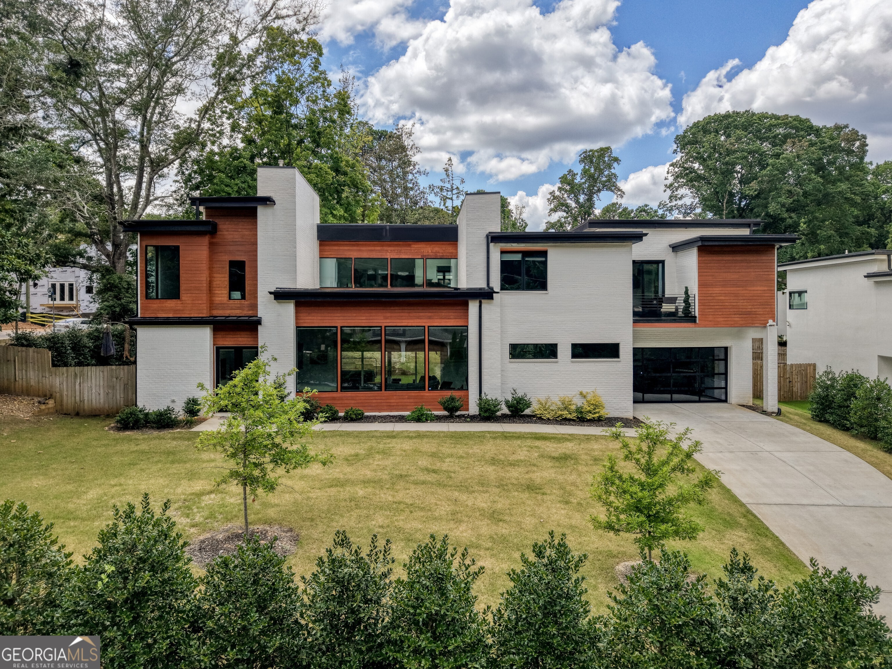 Welcome to this 2023-built LaVista Park GEM by award-winning Six Points Homes - a flawless fusion of modern design, luxury finishes, and unbeatable location. Nestled just minutes from Midtown, Atlanta BeltLine, Buckhead, Ponce City Market, Atlantic Station, Piedmont Park, Emory University, Oglethorpe University,Childrens Hospital of Atlanta(New location),Lifetime Fitness, as well as quick easy access to interstates(85,400,75) this home offers the best of intown living with the convenience of Brookhaven City services. From the moment you arrive, the curb appeal captivates with striking brick construction, warm wood accents, black metal-framed windows, oversized 8' double front doors, and a custom designer garage. Step inside to soaring 13' ceilings, wide-plank hardwoods, and a bright, open floor plan designed for both elegance and comfort. The fireside great room is flooded with natural light and flows seamlessly into the chef's kitchen - complete with a massive quartz island, JennAir stainless appliances, exposed wood shelving, and sleek modern cabinetry. A spacious main-level bedroom with a full bath and private entrance is perfect for guests, a home office, or multi-generational living. Upstairs, the primary suite impresses with 12' tray ceilings, private balcony access, and a spa-style bath featuring a floating dual vanity, soaking tub, and oversized dual-head glass shower. Dual walk-in closets are fully outfitted with custom shelving. Three additional en-suite bedrooms and a versatile loft/media space complete the upper level. This smart home includes two Nest thermostats, remote lights, electric blinds, AI camera system, ADT Security, Level 2 charger, and remote-access features for convenience and energy efficiency. Outdoors, enjoy a covered fireside patio with a ceiling fan and level, fenced backyard - ideal for relaxing, entertaining, or pets at play. LaVista Park is a tranquil, walkable neighborhood, with its own green space just 8 minutes away, and you're under 5 minutes from Grocery stores dining, and shops. Experience the perfect blend of luxury, smart living, and city access - all in one of Atlanta's most sought-after neighborhoods.