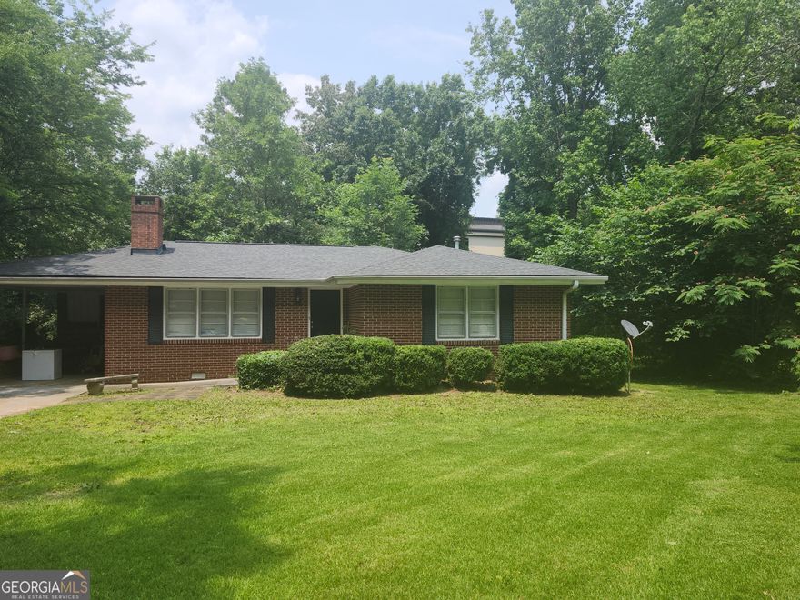 This delightful ranch-style residence offers classic charm with a welcoming front yard and a location just minutes from Rome's popular shopping and dining spots. Inside, gleaming hardwood floors lead you through a comfortable living space anchored by a cozy fireplace-perfect for relaxing evenings. The kitchen features abundant cabinet storage and a layout ideal for both everyday use and entertaining. Each bedroom provides a peaceful retreat with natural light and inviting comfort. Step outside to a private backyard, a serene space surrounded by mature greenery, ideal for outdoor dining, gardening, or quiet mornings with a cup of coffee. A perfect blend of convenience and comfort in a tranquil setting.