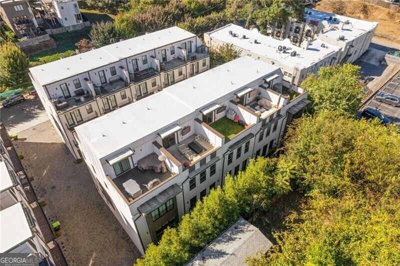 Welcome to 574 Boulevard Place NE #3, a stunning 4-level townhome in the heart of Old Fourth Ward that blends modern design with everyday comfort. Just a short walk to Ponce City Market, the Eastside BeltLine Trail, and all the best of intown Atlanta, this home offers a Walk Score of 88 and the lifestyle to match. Inside, a private elevator connects all four levels, starting with a spacious 2-car garage and a full bedroom suite with private bath and an artistic accent wall-perfect for guests, a quiet workspace, or a creative studio. Upstairs, the chef's kitchen features a 6-burner Wolf range, professional vent hood, quartz countertops, marble herringbone backsplash with hidden outlets, under-cabinet microwave, and sleek, glossy ceiling-height cabinets-a standout feature reflecting today's top design trends that favor style, function, and personality. The open living and dining areas include a fireplace, designer lighting, and two balconies that invite fresh air and natural light. On the third level, the primary suite spans the entire floor, and includes a balcony, brick accent wall, luxury bathroom with backlit mirrors and under-cabinet lighting, a large custom closet,  and a conveniently located laundry room. The top level offers two rooftop decks with sweeping views of Ponce City Market and the Bank of America tower, along with a wet bar, beverage fridge, full bath, and additional bedroom-perfect for entertaining or retreating in peace. Beautiful and durable engineered hardwoods run throughout, grounding the sleek design in warmth and comfort. This home is stylish, functional, and quietly luxurious-urban living at its finest! (Furnishings are negotiable)