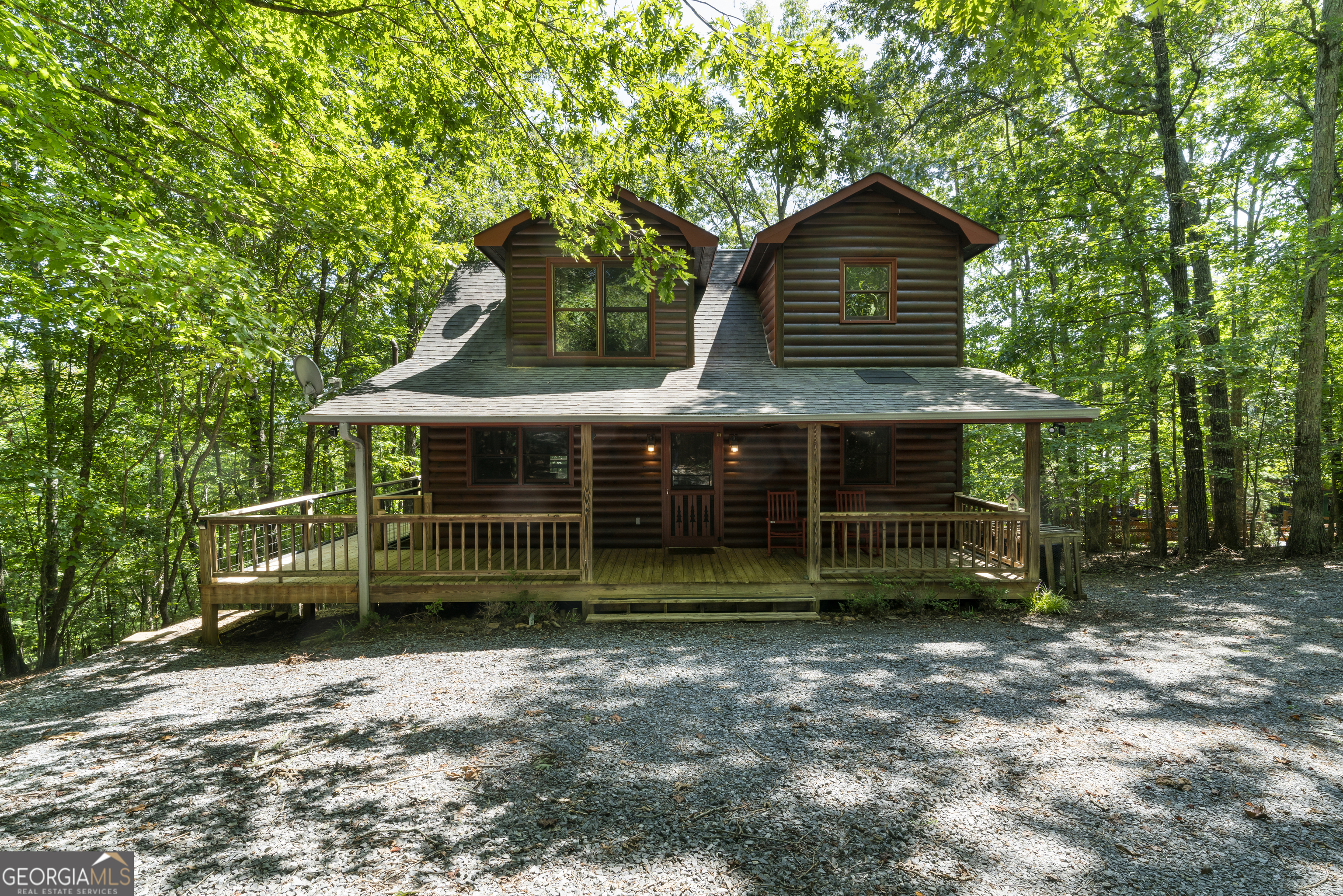 Escape to your private mountain sanctuary in the coveted My Mountain community! With the convenience of all-paved roads, you're just a scenic 10-minute drive from the vibrant shops and dining of downtown Blue Ridge. This immaculate, move-in ready log cabin is a rare find, perfect as a peaceful retirement haven, a multi-generational family retreat, or a high-demand short-term rental investment. Step inside and be greeted by the warmth of a spacious great room, where a crackling wood-burning fireplace invites you to unwind. The open-concept layout flows seamlessly into a modern kitchen, fully updated with brand-new stainless steel appliances. The main level also features a convenient primary bedroom with a full ensuite bathroom, complete with dual 'his & her' sinks. Ascend to the upper level to discover a second private bedroom suite, also boasting a full ensuite bath and double vanities, offering a perfect retreat for family or guests. The fully-finished terrace level is a game-changer, featuring a complete in-law suite ideal for extended stays or as a separate rental unit. This versatile space includes a cozy living area with a gas log fireplace, a brand-new kitchenette, a sleeping area, and a full bath. Your outdoor oasis awaits! Entertain and relax on the brand-new, two-story deck, perfect for grilling while overlooking your private, wooded lot. Spend your evenings sharing stories around the newly built stone fire pit or soaking in the hot tub on the peaceful, screened-in porch-a true year-round luxury. With recent major upgrades, an ideal location, and a floor plan built for comfort and income, this is the Blue Ridge opportunity you've been waiting for. Don't let this dream slip away. Schedule your private showing today and start living the mountain life!