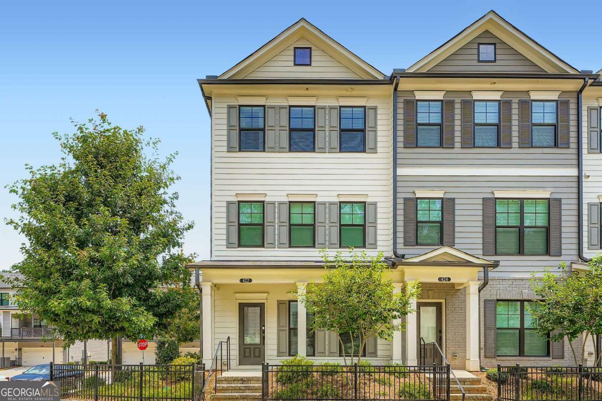 Discover this stunning end unit townhome, custom built just three years ago in Woodstock, GA. Offering 3 bedrooms and 3.5 bathrooms across three spacious levels, this beautifully designed home features an inviting eat-in kitchen with 42" white cabinets, bronze hardware, quartz countertops, and a spacious gray island perfect for casual dining. The open-concept layout seamlessly connects the kitchen, dining, and living areas, anchored by a cozy shiplap-accented fireplace. Step out onto the expansive covered deck, ideal for relaxation or entertaining. Each bedroom includes its own private full bath, while the primary suite boasts a generous walk-in closet, dual sinks, and a luxurious mega tile shower. Located in a gated community with included lawn care and exterior maintenance, this home is just off Highway 92 in the highly rated River Ridge School District. With stylish finishes and a smart layout, this townhome is the perfect blend of comfort and style-schedule a showing today! Discounted rate options and no lender fee future refinancing may be available for qualified buyers of this home.