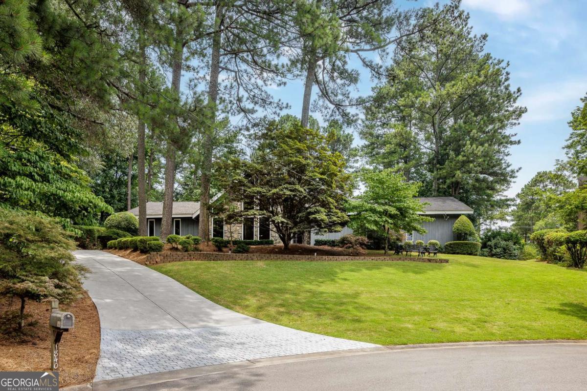 A rare find in Dunwoody! This striking contemporary offers true one-level living with a spacious open floor plan, soaring vaulted ceilings, and dramatic floor-to-ceiling windows that flood the home with natural light. Located on a quiet cul-de-sac and just a short walk to top-ranked Vanderlyn Elementary, this home combines modern style with everyday comfort. Step inside to a vaulted dining room and great room that opens seamlessly to the outdoors and a walkout heated fenced pool-a peaceful, private retreat perfect for relaxing or entertaining. A beautifully designed room addition with custom leaded glass doors adds extra flexibility for living, working, or gathering. The sleek, modern kitchen features Caesarstone countertops, custom cabinetry, and stainless steel appliances. The oversized primary suite is located on the main level and has been expanded with access to the pool plus a sizable upgraded bath and a walk-in closet. Additional features include a newer driveway, architectural roof, dual HVAC systems, and a large powered storage shed- for tools, hobbies, or pool equipment. There's also plenty of space to add a garage or pool house. Thoughtfully updated, meticulously maintained, and close to top schools, Dunwoody Village, shopping, and parks-this is a special opportunity for a one-of-a-kind gem!