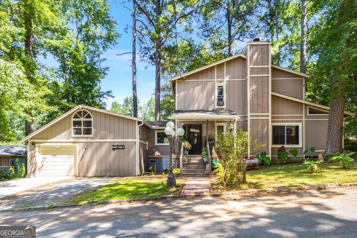 Welcome to 487 Magnolia Drive - this home doesn't whisper, she screams! Set in the artistic enclave of Pine Lake, the very entryway dares you to blink. A hall of eyes - bloodshot, bulging, unrelenting - follow your every move. They don't just watch, they leer. At the end of it all, Leatherface reigns supreme, chainsaw cocked like a half-grin, half-threat. This isn't a foyer, it's the slaughterhouse curtain call. The main level sprawls in hardwood and engineered floors, leading you into the kitchen so big, you'll need both hands to handle it. Carnival-colored cabinetry pops like sinful confetti, while the tiki mask stares with voyeuristic hunger - witness to every thrust, every slice, and every slash. Wide open like a dance floor, this isn't just a place to cook - it's where flavors get filthy and the countertops know all your secrets. Swing around to the bonus space - good as a third bedroom, office, or your private den of vices - before stumbling into the guest bath. Step inside this candy-coated den of depravity, where the only thing filthier than the decor is what's about to happen inside! The living room? A neon-lit lair of lust. Cathedral ceilings soar above hardwood floors, with walls set ablaze in searing orange and midnight blue. In the corner lurks a Pepto-pink Nosferatu, stiff and obscene, caught like a pervert mid-peep. It's an invitation to a den of electric sex - a hidden movie room straight out of a retro fever dream and with the promise for a triple feature of fun, fantasy, and just the right amount of naughty nostalgia. And then - the crown jewel, A curvaceous spiral staircase that will make you dizzy with desire."Up you go, Tiger... upstairs is where the action really starts." Two upstairs bedrooms are headlined by the oversized primary suite-complete with a walk-in closet, soaring angled ceilings, and skylights spilling in natural light, too pure for what really goes down here, but perfect for a lens capturing every angle. The renovated bath burns hot in tropical shades of orange, red, and blue, more beachside boudoir than suburban washroom. A bold ocean-blue double vanity, wide mirrors, a deep tub, and a shower that's so steamy, it needs a safe word. This isn't hygiene, it's foreplay. Step outside and you'll find a backyard larger than most-fully fenced for your most private indulgences, anchored by a generous deck and tiki bar that begs you to bring the after-hours party home. Even the oversized two-car garage comes with room to spare, perfect for hiding away all your dirtiest toys. Offered with the option to stay "as is" in its decadent decor, this home delivers a rare versatility & flexibility only rivaled by the legends at the Clermont. She doesn't just have a floor plan-she's got a body that NEVER quits.