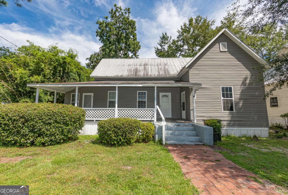 This well-maintained older home is full of charm and character, offering 2 spacious bedrooms, 1.5 bathrooms, and an additional bonus room that can be used as an office or third bedroom. Inside, you'll find a large living room perfect for relaxing or entertaining, beautiful hardwood floors, and a cozy fireplace in the bedroom. The kitchen features a large pantry and connects to an inside laundry area for added convenience. Enjoy mornings and evenings on the covered freshly painted front porch, or spend time in the nice backyard with plenty of room for outdoor living. The property also includes a large carport and the comfort of newer windows throughout. Located within walking distance to the bustling downtown, this home combines classic style, modern updates, and a prime location.
