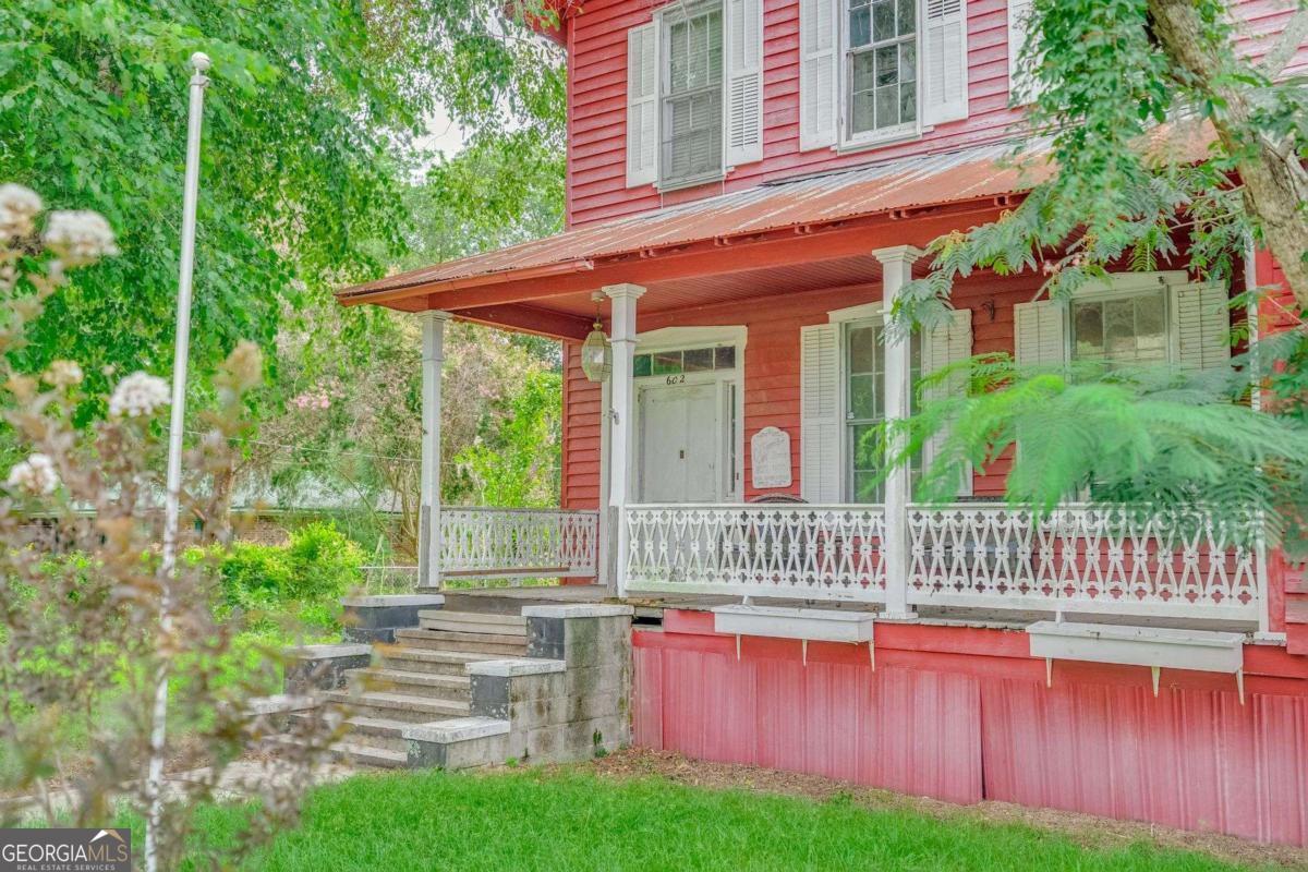 The Colonel Edward Bird House, built in 1870, offers a rare chance to restore a piece of Georgia history. Located on a large corner lot in the Guyton Historic District and listed on the National Register of Historic Places, this 3-bedroom, 2.5-bathroom home spans approximately 3,000 sq ft and retains original features including four fireplaces, hardwood floors, tall windows, and a central staircase. The home requires full renovation but offers strong bones and irreplaceable period details ideal for preservation. Also included is a newly constructed 360 sq ft outbuilding with electrical and plumbing rough-ins-ready to finish as a guest house, studio, or rental. Perfect for renovators or investors looking for a historically significant project with long-term value. Property sold as-is.