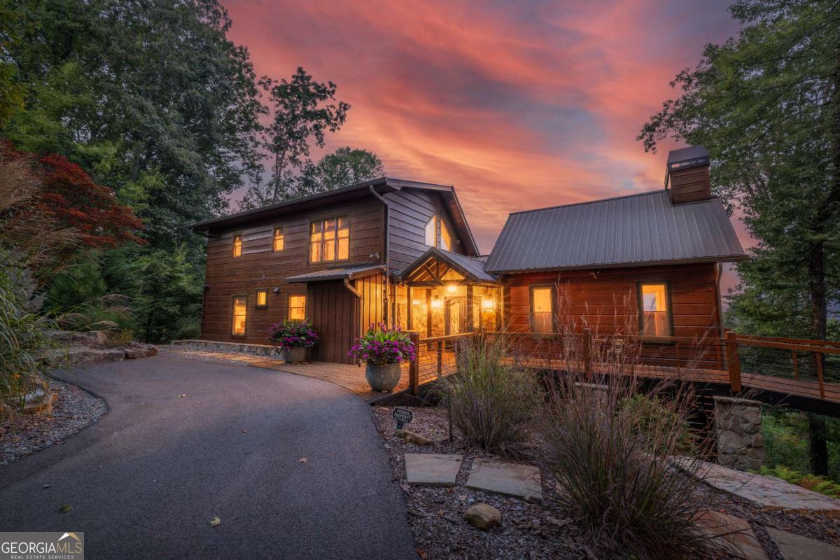 Welcome to your dream retreat in the Cherry Log Mountains, perfectly nestled between the vibrant downtowns of Blue Ridge and Ellijay. This charming cabin offers unparalleled long-range mountain views and promises a serene lifestyle amidst nature's beauty. As you approach, you'll be greeted by the home's gorgeous curb appeal, accentuated by professional landscaping and a colorful sanctuary of plants thriving on an easy-care irrigation drip system. Step inside to discover a professionally designed, creatively inspired space that seamlessly blends luxury with a mountain vibe. Every window in this cabin frames sprawling, picturesque views, immersing you in the natural splendor of the surroundings. The kitchen is a culinary delight, featuring upgraded granite countertops, high-end KitchenAid appliances, and a convenient butler's pantry complete with a coffee and wine bar and a rare commodity, a GARBAGE DISPOSAL! Cozy up in one of the three spacious bedrooms, each elegantly designed to offer modern comfort. For those who love outdoor relaxation, the expansive decks provide the perfect setting to unwind while enjoying 2.38 acres of private, tree-hugged serenity. This property offers endless possibilities to personalize your sanctuary. Whether you choose to expand into the fully stubbed, ready-to-design apartment garage or create a bonus room in the bottom deck basement area, there's ample room for growth. Whether you're seeking a family getaway, an investment opportunity, or a space equipped for full or part-time easy living, this cabin is a versatile haven ready to meet your every need. Embrace the tranquility and luxury of mountain living in this exceptional Blue Ridge cabin.