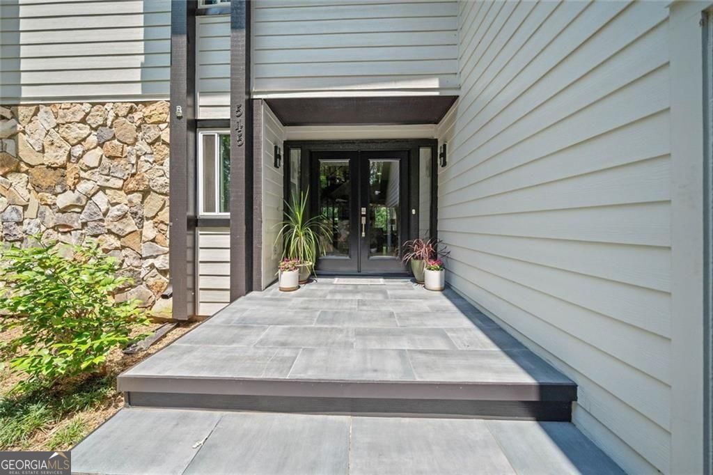 Mountain-Inspired Retreat in the Heart of Johns Creek. Tucked away on a quiet cul-de-sac in the highly sought-after Rivermont community, this bright and spacious 5-bedroom, 3.5-bath home offers the perfect balance of mountain retreat charm and suburban convenience. Step inside to a welcoming two-story foyer that opens to a grand family room featuring vaulted ceilings, a cozy fireplace, and a dramatic wall of windows that flood the space with natural light. The renovated owner's suite on the main level boasts hardwood floors, a luxurious en-suite bath, and a private deck overlooking the peaceful, wooded backyard. The updated kitchen is a chef's delight with granite countertops, newer cabinetry, stainless steel appliances, coffered ceilings, and a breakfast bar. The adjacent keeping room with fireplace flows seamlessly to the expansive deck, perfect for outdoor entertaining. Upstairs, you'll find spacious secondary bedrooms and well-appointed baths, while the finished terrace level offers a billiard/game room, flex space ideal for an office, gym, or additional bedroom, plus unfinished storage/workshop space ready to meet your needs. Enjoy access to Rivermont's private park on the Chattahoochee River, along with proximity to top-rated schools, local dining, shopping, and all the natural beauty of North Fulton County.