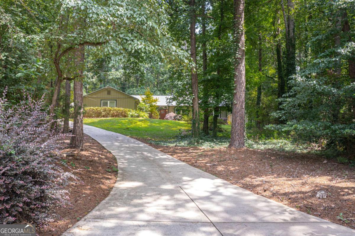 Charming Ranch with Modern Updates and Private Outdoor Retreat. Welcome to this beautifully updated ranch home full of character, nestled on a quiet, private lot with a long driveway and fully fenced backyard-perfect for relaxation, entertaining, and enjoying the outdoors in peace. This spacious 3-bedroom, 2-bathroom home features an open-concept floor plan with newer floors, recessed lighting, and updated light fixtures throughout. The kitchen has been thoughtfully renovated and flows seamlessly into the family room, which boasts a striking brick accent wall for added warmth and charm. The large primary suite offers comfort and privacy with updated finishes. Enjoy outdoor living on the expansive front porch or host gatherings in the generously sized backyard. A new roof was installed in 2021, and both AC units were replaced in 2018-giving you peace of mind and energy efficiency for years to come. Located in a vibrant and welcoming neighborhood, you'll have access to outstanding community amenities including a Junior Olympic-size swimming pool, six tennis courts, a stocked fishing pond, and a scenic park with a waterfall and a rustic car-and-horse carriage bridge. The community also hosts frequent events, making it easy to connect and feel at home. Conveniently close to top-rated schools, shopping, parks, and with quick access to the interstate-this home truly offers the best of comfort, community, and convenience.