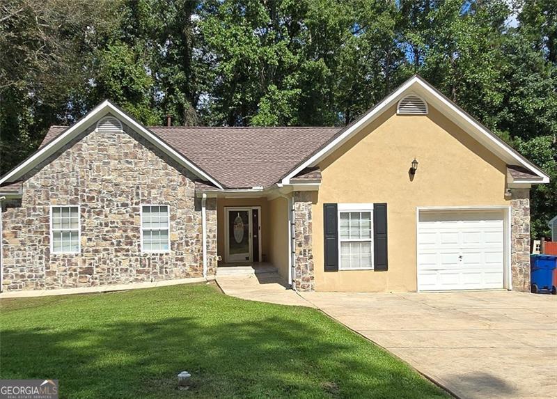 Welcome Home! This beautiful home offers 4 bedrooms, 2.5 bathrooms located in the wonderful neighborhood of Milam Manor in a well-established community of Fairburn. This home provides ample space for enjoyable living, features a living and dining room combo with a fireplace in living room, kitchen with countertops galore, ceramic tile floor, and stainless steel appliances. Enjoy grilling outside on the deck from dining room, all tile bathroom with separate tub and shower, hardwood floors, one car garage, laundry area and hot water heater in garage and a fenced back yard for privacy. Newer roof, privacy fence and deck. This is a great opportunity to make this your dream home! This won't last long on the market.