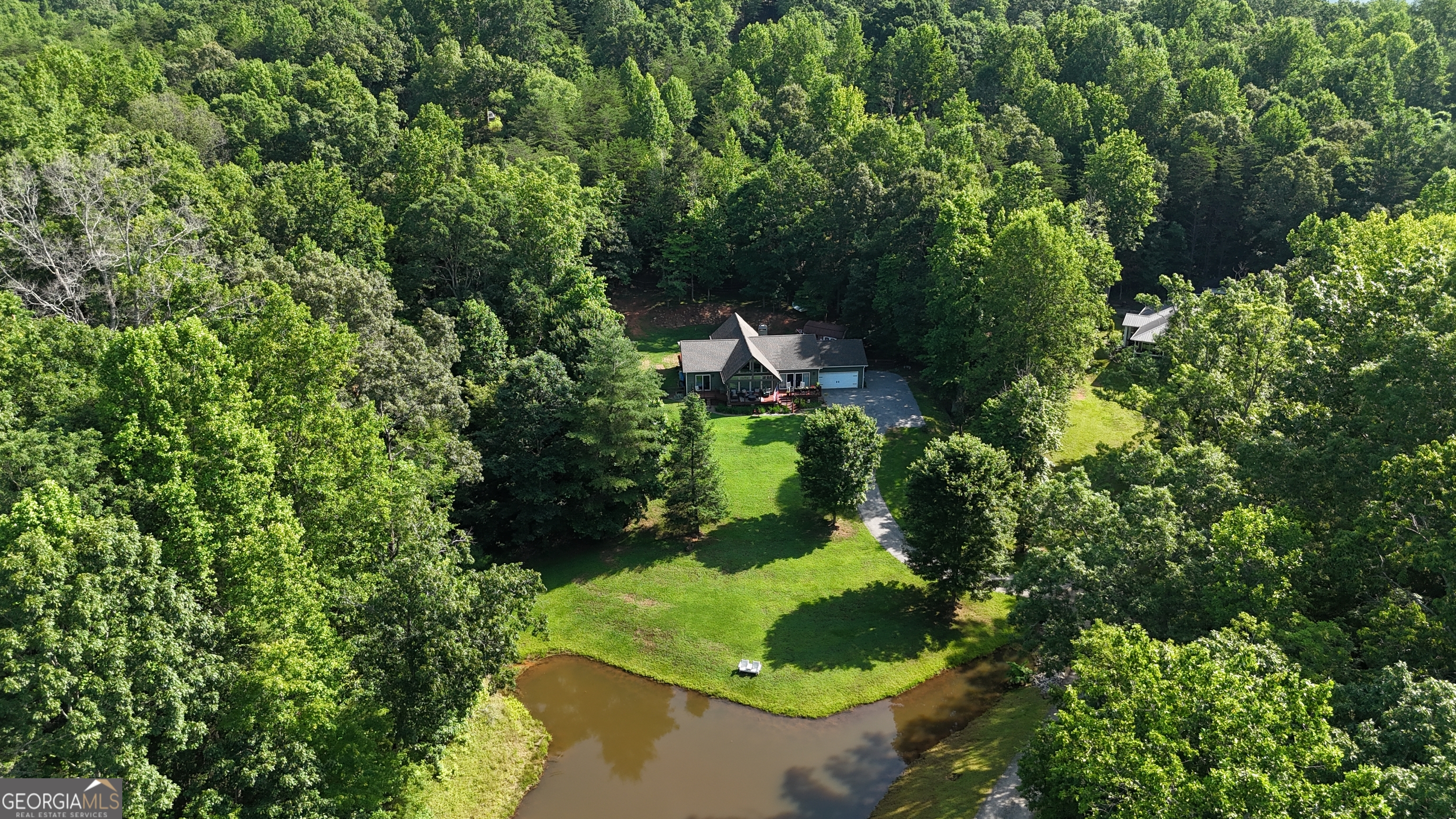 Serene North Georgia Retreat with Pond Views & Modern Upgrades - No HOA, No Restrictions! Welcome to your peaceful slice of North Georgia paradise! Nestled on 1.68 picturesque acres with a tranquil pond in the front yard, this beautiful home offers the perfect blend of rustic charm and modern comfort-without the burden of HOA fees or restrictions. Step inside to find floor-to-ceiling windows and soaring tongue and groove ceilings that flood the home with natural light and bring the outdoors in. The popular open floor plan features hardwood floors throughout, updated lighting and plumbing fixtures, and tiled bathrooms. The spacious living and dining areas flow seamlessly into a modern kitchen with a bar area, solid countertops and plenty of cabinetry. This home features 3 bedrooms and 2.5 baths, including a luxurious master suite with pond views, a walk-in closet that spans the entire width of the room, a soaking tub, and an oversized custom-tiled shower. Two additional bedrooms share a stylish Jack-and-Jill bathroom with a standalone tiled shower. A convenient half bath is located off the main living area, along with a dedicated laundry space just off the kitchen. Enjoy peaceful mornings or relaxing evenings on the covered rocking chair front porch, or step out from any front-facing room onto a private deck to take in the pond views and wildlife. The fenced backyard is perfect for kids or fur babies, with raised garden and flower beds for your green thumb. An oversized all-season bonus room, wrapped in floor-to-ceiling windows, lets you soak in the view year-round, no matter the weather. Off the bonus room is a flex space ideal for a home office, studio, or reading nook. Outside, entertain guests on the open grilling deck, and don't miss the detached utility building-converted into a fun "man cave" complete with a TV and entertaining space. Located just minutes from Helen, downtown Cleveland, and Clarkesville, this home offers easy access to local wineries, restaurants, shopping, hiking, and waterfalls. Whether you're enjoying birdsong on the porch or spotting deer from your deck, this peaceful haven invites you to unwind and reconnect with nature-every day.