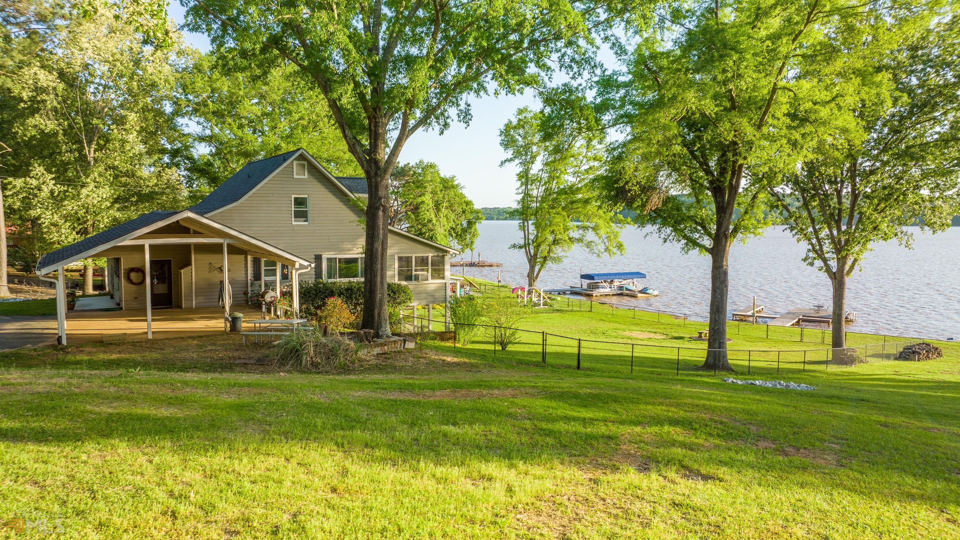 Unbeatable Sunset Views on Lake Oconee! Escape to this spacious 4-bedroom (plus bunk room) lakefront home with all of your family and friends and create unforgettable memories. There is plenty of room to spread out and entertain in this multiple-level home, with two living areas, two kitchens, several outdoor living spaces, a beautifully renovated master ensuite and so much more! A Fenced-in yard, level walk down to the lake, private max dock and concrete seawall make this home a perfect fit for families. A detached garage on the property along with a terrace-level storage area provides room to store all your toys! Enjoy unobstructed big lake views all year long from most rooms in this house including the expansive sunroom or the lower-level covered porch. This is the perfect weekend retreat or a great full-time residence. Located in the Lake Oconee Academy School District. Just minutes from Downtown Greensboro for shopping, restaurants and Oconee Brewing Company and 35 miles to Athens. Summer is almost here, grab this house and start making memories on the lake now!