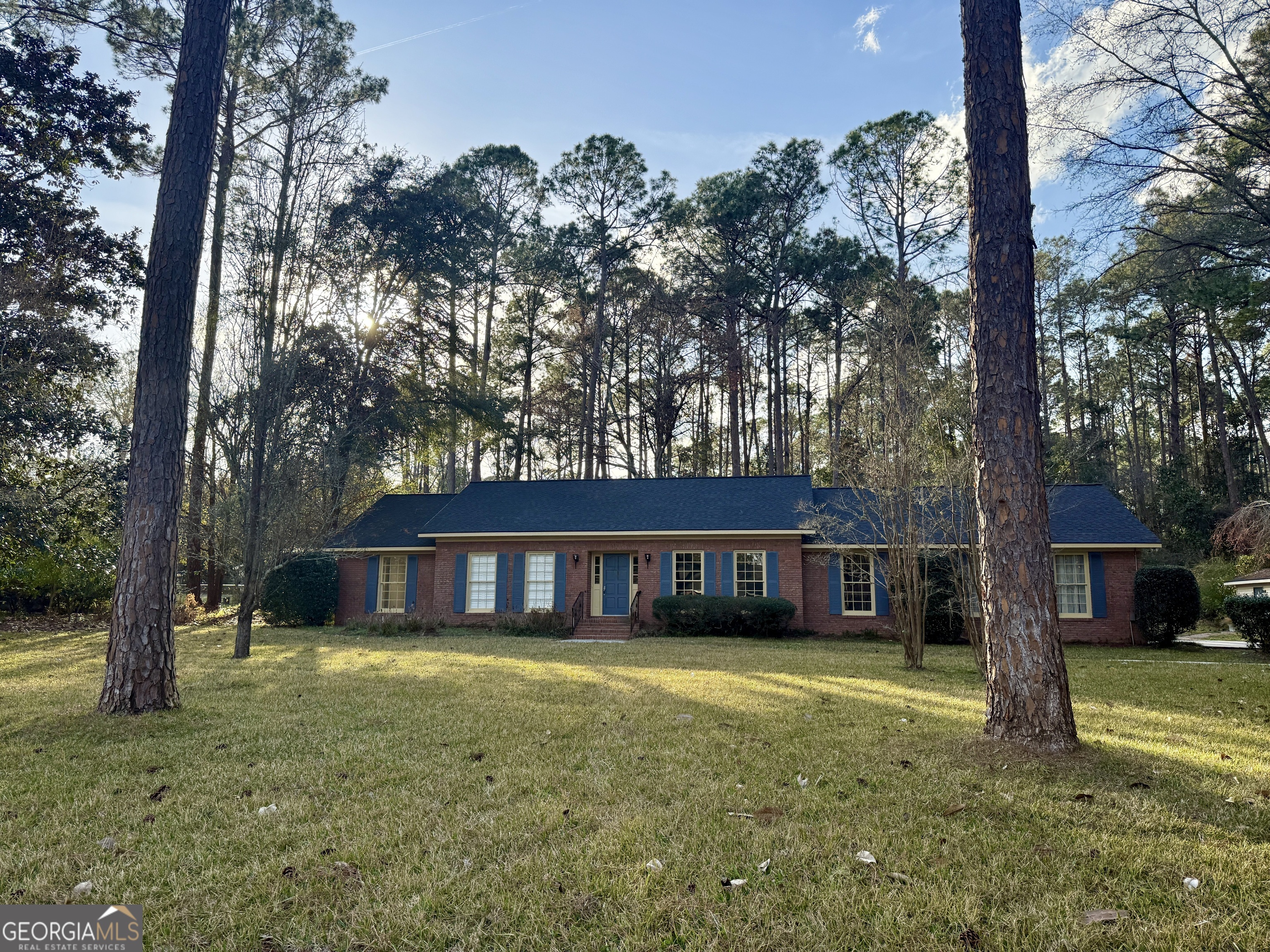 Charming Brick Home with Spacious Living, Stylish Updates & Private Setting! Welcome to 1075 Wildwood Rd, a beautifully maintained brick home featuring 3 bedrooms, 2 baths, and a thoughtfully designed layout. Nestled at the end of Wildwood Rd, this home offers privacy and tranquility, surrounded by wooded land on both sides-a peaceful retreat while still being conveniently located. This inviting home has been enhanced with new flooring, new countertops, and an updated primary bathroom, making it truly move-in ready for its next owner! As you step inside, the welcoming foyer is filled with natural light from large windows, creating a bright and airy atmosphere. Just off the foyer, a formal dining room and formal living room provide elegant spaces perfect for entertaining. The living area is the heart of the home, featuring a charming brick fireplace opposite built-in bookshelves, adding warmth and character. The adjacent kitchen has been refreshed with new countertops, providing ample workspace and storage. Nearby, a spacious laundry room offers extra convenience and leads to the attached garage. The primary suite is a relaxing retreat, now boasting a fully updated bathroom, including a double vanity with plenty of cabinet space and a beautifully tiled shower with a glass door. Down the hall, two additional bedrooms feature large windows, and the hall bath offers a practical design with the vanity area separate from the shower for added functionality. Step outside to enjoy the expansive screened-in brick-covered porch, complete with a vaulted beadboard ceiling-a perfect space to relax and take in the lush, well-maintained backyard. Whether you're hosting guests or enjoying quiet evenings outdoors, this space is truly a retreat. With its private wooded setting, charming character, thoughtful updates, and inviting spaces, this home is the perfect blend of comfort and style. Don't miss your opportunity to make it yours!