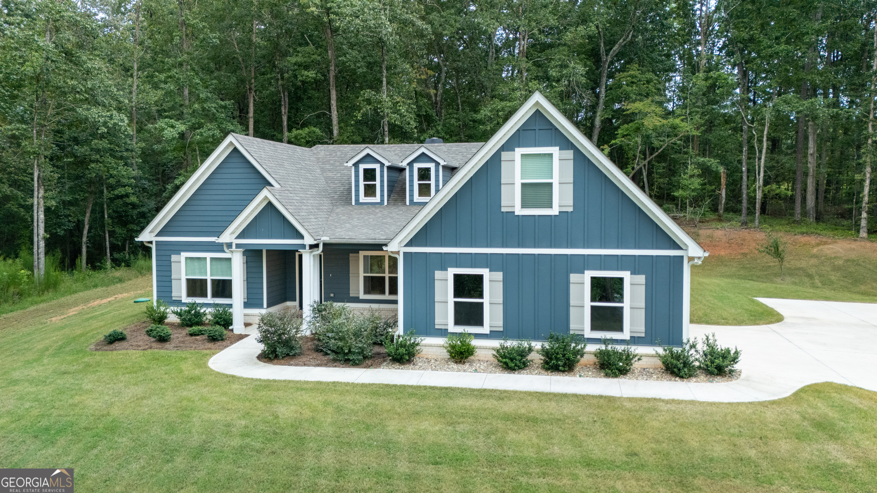 WELCOME HOME to this stunning 4-bedroom, 3-bath ranch/craftsman-style home in the desirable Deer Creek community of Moreland GA. Here, small-town charm blends with peaceful, wooded surroundings, creating the perfect retreat for both relaxation and gathering with family and friends. Tucked away at the end of a quiet cul-de-sac on 3.01 wooded acres, this home offers both privacy and natural beauty. From the moment you arrive, the inviting front porch calls for rocking chairs or a porch swing, an ideal spot to slow down and soak in the setting. Step inside and you'll immediately notice the open, airy flow that connects the foyer, formal dining room, family room and a cozy bonus room. A designer fireplace and a vaulted ceiling anchor the space, creating warmth and ambiance that can be enjoyed from multiple rooms. Sunlight pours in, and French doors invite you outdoors to one of the two covered patios, perfect for extending your living space into the fresh air. The heart of the home is the gourmet kitchen, where shaker-style cabinetry, stainless steel appliances, subway tile backsplash, and a large island with breakfast bar combine both style and function. A generous walk-in pantry ensures plenty of storage, while the open design keeps you connected to the family room and breakfast area. Another set of French doors here leads to a second covered patio, perfect for sipping morning coffee or firing up the grill. Conveniently located near the kitchen, the laundry room and garage entry include space for a future drop zone--ideal for organizing coats, bags, and shoes. Tucked privately on one side of the home, the owner's suite is a true retreat, complete with a spa-like bath featuring a soaking tub, tiled walk-in shower with glass enclosure, dual vanities, linen closet and oversized walk-in closet. On the opposite side, two additional bedrooms share a spacious full bath, creating a functional split-bedroom layout. Upstairs, a private suite with bedroom, full bath and walk-in closet offers flexibility, whether for guests or multi-generational living or a quiet home office. Throughout the home, you'll find thoughtful details like tray and vaulted ceilings, upgraded trim, luxury vinyl and tile flooring, soothing color palette, and Smart Home Technology. Energy efficient features such as foam-insulated attic, Low-E windows, and architectural shingles add peace of mind. Outdoor living is equally inviting, with two covered back patios overlooking a peaceful wooded backyard, an ideal backdrop for quiet evenings, weekend cookouts, or fall football gatherings. A two-car garage with an extra parking pad completes the package. Just minutes from I-85, you'll enjoy easy access to Newnan, Peachtree City, Atlanta, Fayetteville, LaGrange and beyond while still coming home to the peace and privacy of your wooded retreat. Barely lived in and meticulously maintained, this home is ready to welcome its next chapter...YOURS!!