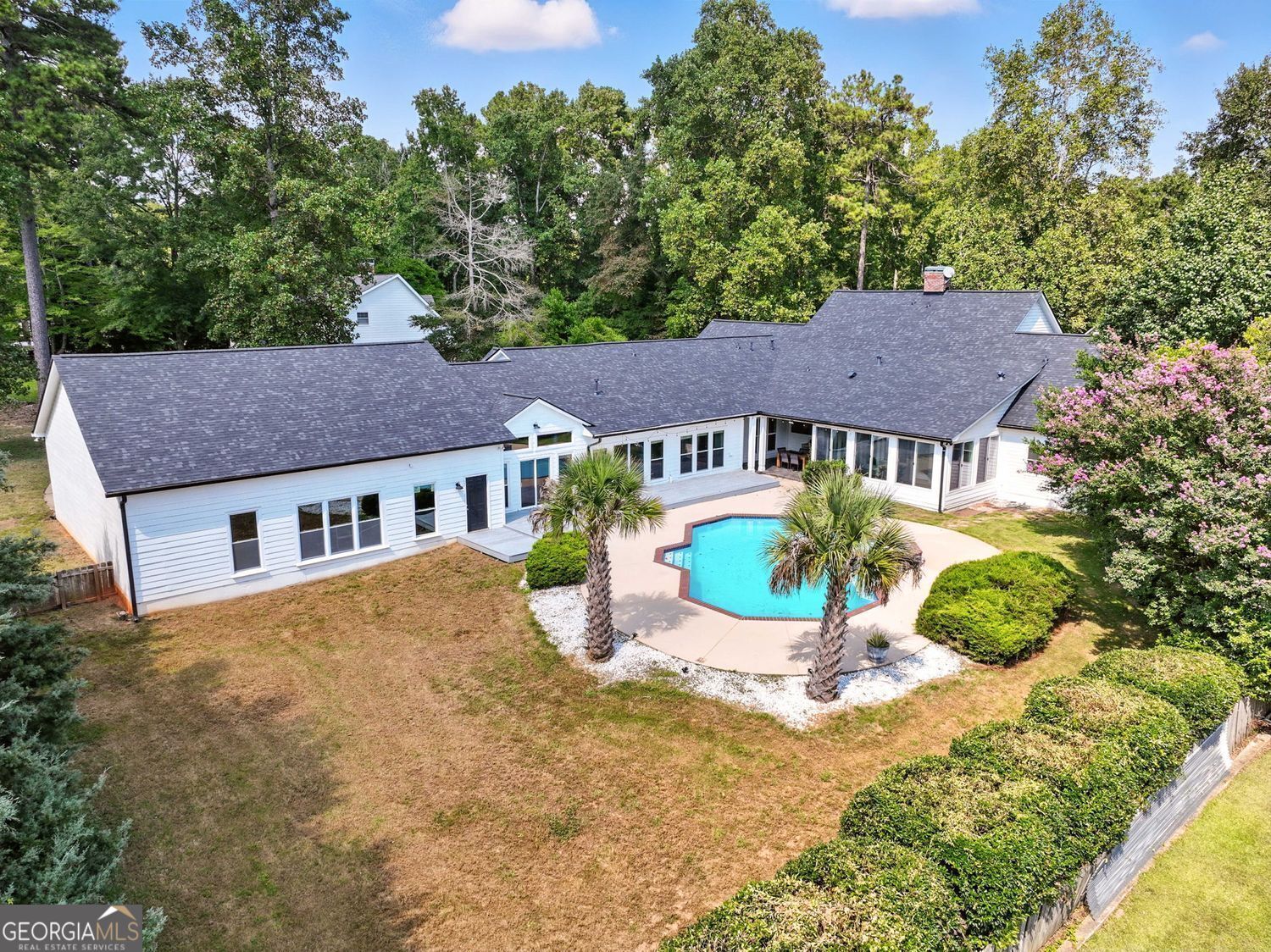 Welcome to your private retreat in the Lake Spivey community. This 4 bedroom, 4.5 bath home offers just under 4,000 square feet on more than an acre, complete with access to the community dock for boating and lake enjoyment. Recent upgrades provide peace of mind with fresh interior and exterior paint, brand new flooring, a new roof, new siding, two new HVAC systems, smart thermostats, and a security system. Inside you'll find a spacious layout with a large family room, formal living and dining areas, and an eat-in kitchen. A second kitchen and wet bar area create the perfect setup for entertaining. The oversized owner's suite features a spa-like bath and a custom closet, while an additional office or optional fifth bedroom offers flexibility. Step outside to your own resort-style backyard with a sparkling pool featuring new gunite, pump, and filter. A covered outdoor kitchen and patio provide the perfect space for gathering with family and friends. Car enthusiasts will appreciate the 8-car garage and expansive driveway with plenty of room for guests. Whether hosting by the pool or enjoying quiet mornings by the water, this home delivers the lifestyle Lake Spivey is known for.