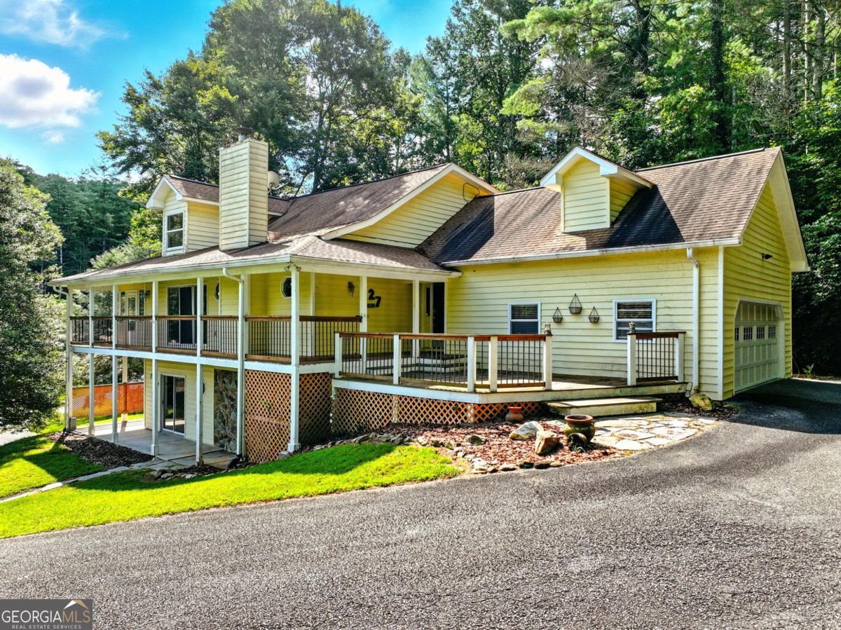 Find lakefront bliss in this charming & spacious home that sits on the peaceful shores of Lake Nottely. Tucked within a quiet, established community yet just minutes from the heart of Blairsville or an easy drive to Murphy, NC & endless outdoor adventure. Enjoying the spacious front deck & porch leading inside to an inviting great room with a feature stone fireplace, hardwood floors, vaulted ceilings & a blend of drywall & wood accents that add character & charm. Sliding glass doors flood the space with natural light & open to a rear porch to savor the lake view, plus an enclosed porch to enjoy the outdoors in any season. The kitchen is well-laid out & has an island, tons of cabinets & granite countertop space, farmhouse sink, upgraded stainless steel appliances & pantry. The main level master includes sliding doors onto the enclosed porch & has an ensuite bath with freestanding soaking tub, tiled shower with glass enclosure & a huge walk-in closet with glass paned barn doors. There is a connected separate toilet & vanity room that also has access to the hallway leading to the laundry room for convenience. Upstairs, a loft with lake views & a closet offers flexible space for additional guests, a home office, or as additional living space. A bedroom & full bath complete the upper floor. The terrace level is a home within itself, ideal for multi-generational living, guests, or rental potential. It includes a living area with its own patio to enjoy the serene lake views, full kitchen with laundry, 2 bedrooms & a beautifully updated bath with a walk-in tiled shower. This property includes 2 lots spanning both sides of the road, protecting your view & adding value. Enjoy the secondary lot's lakeside gazebo that is perfect for morning coffee, evenings enjoying the fireflies, or easy access to swim & paddle. Whether you're seeking a full-time residence, second home, or an investment opportunity, this Lake Nottely gem is the complete package. TVA Dock Permit on file.
