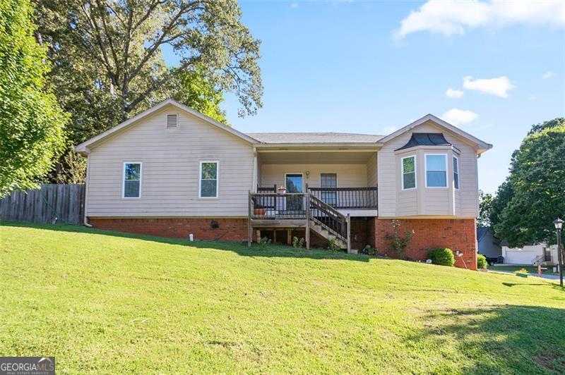 Welcome to this 3-bedroom, 2-bath home with full basement in Lawrenceville! The vaulted family room features tile floors and a brick fireplace, while the large kitchen offers ample cabinets, stainless steel appliances, and a brand-new dishwasher to be installed 9/6/25. The primary suite includes a tray ceiling, walk-in closet, and spa-style bath with soaking tub, dual vanities, and tiled shower. Two secondary bedrooms share an updated hall bath. Full unfinished basement offers storage or expansion potential. Outdoor living includes a covered porch, deck, fenced yard, and landscaped garden. Seller is offering a $4,000 paint allowance and termite bond is active through April 2026. Convenient to schools, shopping, dining, and parks.