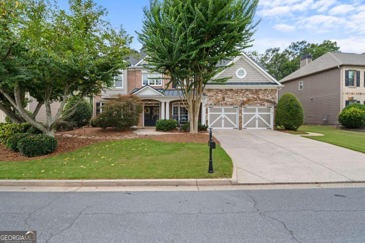 Welcome to this stunning 5-bedroom, 4-bathroom home located in the highly sought-after Lakefield Manor community, known for its exceptional amenities and vibrant lifestyle. This neighborhood offers a swimming pool, tennis and pickleball courts, playground, scenic walking trails, a lake stocked with fish, and a beautiful central park that hosts seasonal events throughout the year. This home stands out as one of the largest floor plans in the neighborhood and boasts a captivating front elevation featuring a combination of brick, stone, and shake shingles with HardiPlank siding wrapping around three sides. The inviting front porch and grand double-door entrance set the tone for the luxury that awaits inside. Upon entry, a two-story foyer welcomes you and opens up to a formal dining room on the right and a versatile living room or home office on the left. The main level includes a spacious guest bedroom and full bathroom, ideal for visiting guests or multi-generational living. The heart of the home is the chef's kitchen, complete with a large island, granite countertops, a tile backsplash, abundant cabinetry, and a walk-in pantry, offering ample space for cooking, entertaining, and storage. A casual dining area off the kitchen is perfect for family meals and morning coffee, while the grand living room impresses with its coffered ceilings, floor-to-ceiling windows that flood the space with natural light, a cozy fireplace, and custom built-in bookshelves, all enhanced by elegant plantation shutters throughout the home. Upstairs, the oversized primary suite is a true retreat, featuring a serene sitting area, tray ceilings, and large windows that bring in abundant natural light. The beautifully updated primary bathroom includes dual vanities with generous counter space, a separate soaking tub, a frameless glass shower, and a spacious walk-in closet. This level also includes a conveniently located laundry room, a secondary bedroom with an ensuite bath, and two additional bedrooms connected by a Jack-and-Jill bathroom. For added flexibility, there is a large media room that could easily function as a sixth bedroom, home theater, or playroom. Outside, the level fenced backyard offers a perfect setting for outdoor gatherings, playtime, or simply relaxing in a private oasis. This home not only offers an exceptional floor plan and luxurious finishes but is also part of an active, friendly community that hosts a variety of events throughout the year, making it an ideal place to call home. Beyond your home, you're just 10 minutes from the charming Marietta Square, offering fine dining, boutique shopping, seasonal events, and live concerts.For outdoor enthusiasts, Kennesaw Mountain trails are just a 5-minute drive away, perfect for hiking and reconnecting with nature. And if you're a sports lover, you're only 20 minutes from Battery Atlanta, where you can enjoy Braves games, concerts, events, and a variety of restaurants.