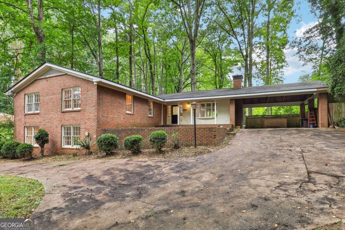Tucked away off the road in a serene wooded setting with mature trees, this renovated home offers bright, open living spaces! Wood floors flow throughout the main level, where the living room impresses with soaring vaulted and beamed ceilings, a dramatic floor-to-ceiling brick fireplace, and walls of windows flooding the space with natural light. The kitchen boasts sleek European-style cabinets, stainless steel appliances, an oversized stainless apron-front sink, and a bright dining room. A second living room offers abundant natural light and another cozy fireplace. The oversized primary suite features dual closets, a reading nook, and an updated en-suite bath with a fully tiled walk-in shower. Two spacious secondary bedrooms and a full hall bath provide comfort for everyone. On the fully finished terrace level, you'll find two expansive open living areas-ideal for a game room, media space, home office, craft room, or playroom-along with two bedrooms, a full bath, and a wet bar with space for a refrigerator. Recent updates include a new roof, HVAC, and water heater, ensuring peace of mind for years to come. Book your tour today!
