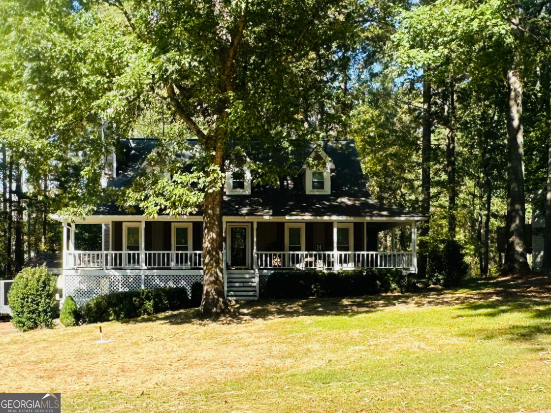 Nestled in a peaceful, well-established neighborhood, this beautiful home has so much to offer. Enjoy relaxing on the large covered front porch that wraps around to the side, perfect for morning coffee or evening gatherings. Inside, hardwood floors flow throughout the main level, accented by elegant crown molding and a cozy wood-burning fireplace. The kitchen features stainless steel appliances, granite countertops, and plenty of workspace. The primary suite on the main level offers LVP flooring, a spacious bath with double vanity, tile floors, a separate soaking tub and large walk-in shower. Upstairs are two oversized bedrooms and a full bathroom, offering plenty of space for family or guests. The finished portion of the basement includes its own heating and cooling system and a bar area-ideal for entertaining or additional living space. Outside, you'll find a recently upgraded back porch overlooking a fenced backyard, with the property line extending into the private wooded area beyond. A 36x30 insulated shop with heating, cooling, and epoxy floors provides endless opportunities for work or hobbies. Additional highlights include all HVAC systems less than six years old and a newly upgraded seven-chamber septic tank. This home perfectly blends charm, functionality, and potential-ready to welcome its next owner. **Professional photos will be added 10/21/25**