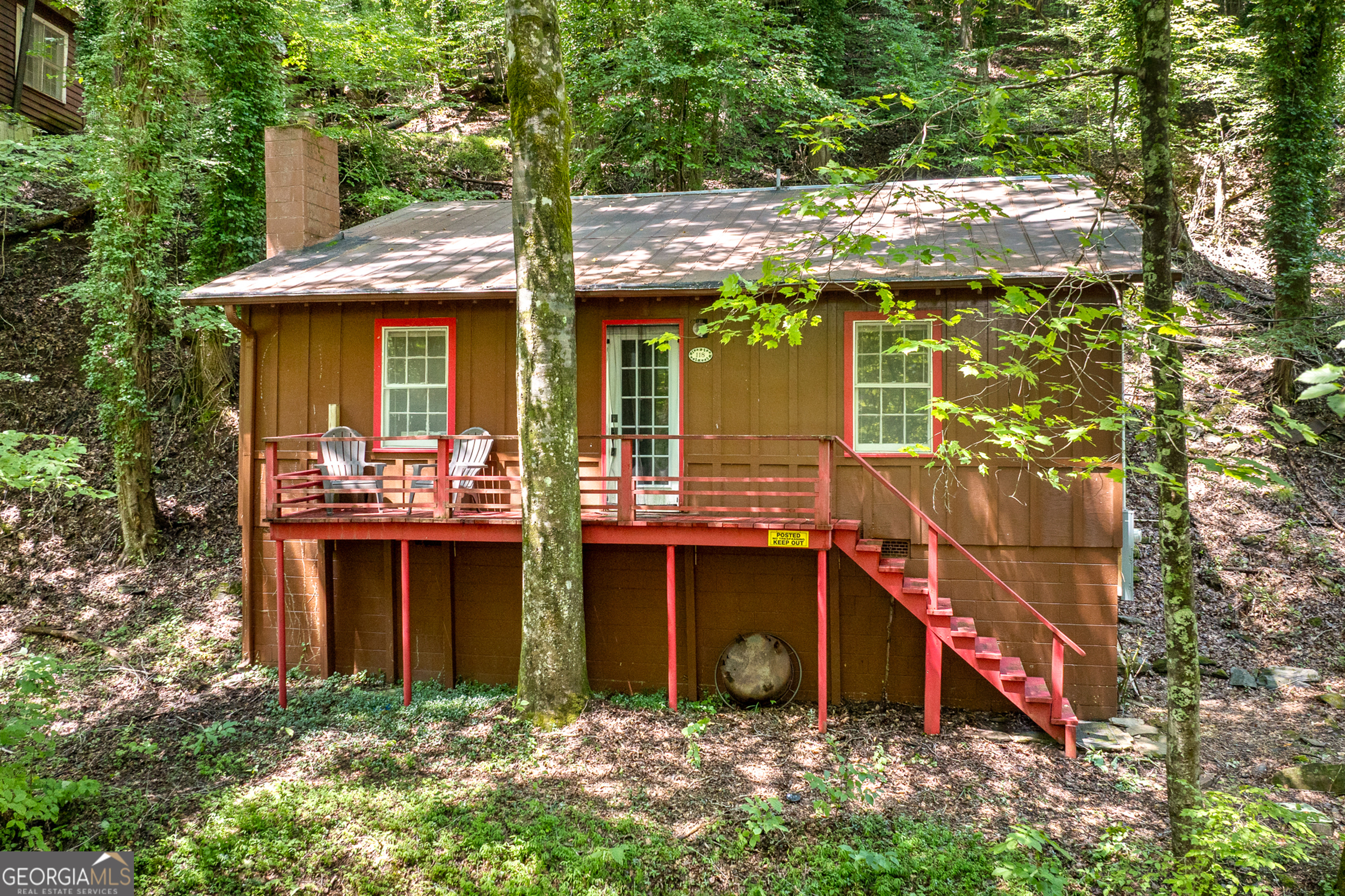CREEKSIDE SERENITY WITH THE SOUNDS OF CANE CREEK WATERFALL! - Your North Georgia Mountain Retreat Only minutes from the heart of Dahlonega, Restaurants, Wineries, Hiking Trails, and more! This charming cabin offers the perfect blend of rustic comfort and natural beauty. Situated directly on a pristine mountain creek, the property features a large breathtaking waterfall just steps away-visible from your front porch and audible day and night, creating an atmosphere of peace and tranquility. Whether you're looking for a part time escape from the hustle and bustle of the city or a high-demand short-term rental, this cabin checks all the boxes! Imagine waking up to the sound of cascading water, sipping coffee on the porch as mist rises from the creek, and ending your day with the soft glow of fireflies dancing along the water's edge. This property is privately deeded and is not considered part of Camp Glisson, yet you have the peace of mind of a gated community. As you enter the home you will find a cozy Living Room with Vaulted Ceilings Open to the Kitchen/Dining area with beautiful views from every window. Just a few stairs to the Split 2 Bedrooms separated by a Full Bathroom with a claw foot tub/shower. Don't miss out on the RARE opportunity!