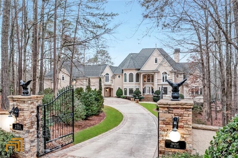 Breathtaking waterfront equestrian estate located in the heart of Milton, Georgia, and now offered on 18+ acres. The 12,900 square foot home is a Mediterranean-inspired masterpiece with expansive living spaces, six bedrooms, six full bathrooms, two half bathrooms, a gentleman's study, a music room, a fully finished terrace level with multiple entertainment spaces, and a three-car oversized garage. The equestrian amenities were thoughtfully designed by a true horse person and include an eight-stall barn with extra-wide concrete center aisle, European stall fronts, climate-controlled feed and tack room, hot/cold wash stall, washer/dryer, and automatic fly system; a spacious two-bedroom + loft groom/caretaker's apartment and barn office; recently resurfaced 190' x 90' lighted arena with river quartz sand; three-bay storage barn; and multiple-sized grass paddocks and pastures with four-board wood fencing. The heart of the magnificent estate home is its chef's kitchen designed by Buckhead's Design Galleria and has an integrated Sub-Zero refrigerator, freezer, and wine/beverage center; double Bosch dishwashers; Viking French-door double oven; Wolf range; oversized warming drawer; and custom cabinetry with beautiful stone counters. The main level owner's suite features a fireplace, sitting room, morning bar, and heated travertine floors in the bathroom. The upstairs has four bedrooms with en suite bathrooms, including a private apartment with a full kitchen. The terrace level has a 2000-bottle wine cellar, full wine bar, media room with fireplace, winemaker's kitchen, sauna, flex room, full bedroom, and full bathroom. The backyard overlooks Starnes Lake and is an entertainer's dream, featuring a saltwater Pebble Tec pool & spa; pool house with wet bar, bathroom, and covered dining; upper patio with full outdoor kitchen; and fireplace with sitting area. The property has a climate-controlled workshop that is a hobbyist's dream, perfect for a car collector, batting cage, or shooting range; a large greenhouse; chicken coop/run; and dog kennels. The sizable vineyard, established in 1998, has both French and American varietals. The fruit orchard offers apples, pears, peaches, blueberries, and blackberries. This exceptional property has something to offer to everyone. It is zoned for the desirable Cambridge High School and conveniently located just five miles from historic downtown Alpharetta, Milton's Market district Crabapple, and world-class shopping at Avalon. For equestrians, it is just four miles to Dover Saddlery, six miles to Atlanta Saddlery and Wills Park Equestrian Center, one hour to Georgia International Horse Park, and three hours to Tryon International Equestrian Center.