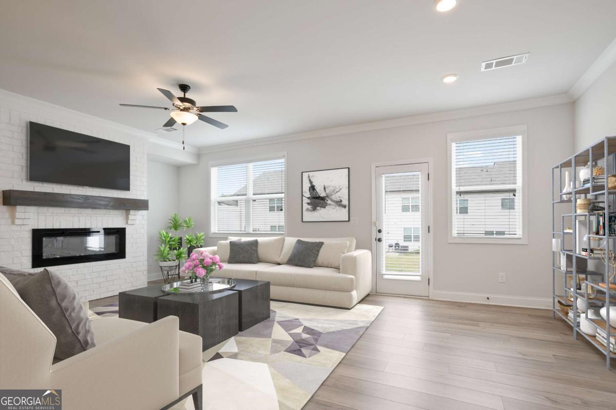 Discover modern living in this beautifully designed Gainesville townhome, offering 3 bedrooms, 2.5 bathrooms, and a spacious 2-car garage. The kitchen features soaring ceilings and sleek white cabinetry, creating a bright and airy feel throughout. An open-concept layout flows into the inviting family room, highlighted by a striking electric fireplace-perfect for relaxed evenings at home. Upstairs, the impressive primary bathroom offers a spa-like atmosphere with upscale finishes and thoughtful design. The master suite is a peaceful retreat with ample space and natural light. Two additional bedrooms share a well-appointed full bath, ideal for family or guests. Washer, dryer, and refrigerator are included, adding extra convenience to this move-in ready home. This property stands out for its pristine condition, offering the comfort of a well-kept residence without the wait of new construction. Filled with charm, it's the perfect blend of style and practicality.