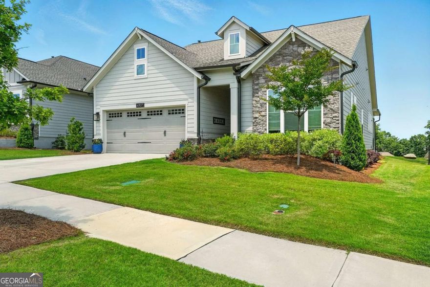 Discover the perfect blend of luxury, comfort, and functionality nestled in the heart of Flowery Branch, Georgia.  This remarkable residence in the coveted active adult community of The Retreat at Sterling on the Lake offers an unparalleled living experience. With three spacious bedrooms, three full bathrooms, a dedicated home office, and an upstairs bonus room, this smart home is a testament to thoughtful design and luxurious comfort.    From the moment you step through the front door, the home exudes sophistication and charm. Your journey begins in the impressive rotunda, which sets the tone for the architectural elegance that unfolds throughout the property.  The open concept layout connects the kitchen, dining, and family room in a fluid and inviting space, ideal for hosting gatherings or simply enjoying quality time with loved ones cozied up to the fireplace. The kitchen is a masterpiece of modern design, featuring a spacious island with pristine quartz countertops that provide ample workspace for culinary creativity.  Adding to the kitchen's allure are thoughtful additions such as a custom coffee bar tucked away in the pantry, perfect for energizing mornings, and a custom-made dry bar designed for evening drinks and relaxation. The 8-foot sliding glass doors invite sunlight and lead to the expansive covered extended rear porch, where the breathtaking view of Sterling on the Lake creates a serene backdrop for outdoor living. Whether it's enjoying the morning sunrise or witnessing the spectacular annual 4th of July fireworks show, this outdoor space is a highlight of the home.  The owner's retreat is a sanctuary of luxury and comfort. The ensuite bathroom boasts upgraded features, including a zero-entry super shower, dual vanities, and a bidet. A spacious walk-in closet completes the retreat, providing ample storage and a touch of elegance. This space is designed to offer homeowners the perfect environment for relaxation and rejuvenation.  For those who work from home, the enclosed study with French doors offers a quiet and professional setting for productivity. Its versatility allows it to be adapted into a multi-use flex space, catering to various needs such as a library, hobby room, or even an additional guest area.   One of the standout features of this property is the upstairs bonus room, which includes a full bath. This space can serve as a fourth bedroom, a second home office, or a private guest retreat, making the home well-suited for multigenerational living.   This residence is equipped with cutting-edge smart home technologies, including: Ring cameras, an Apple Home doorbell, smart lighting, smart ceiling fans, an electronic shade for the sliding glass doors, and zoned AC with three thermostats.  These features ensure comfort, security, and energy efficiency.  Living in this gated section of Sterling on the Lake means enjoying a wealth of amenities exclusive to The Retreat homeowners including a pool, clubhouse, fitness center, tennis/pickleball courts, and part-time activities director.  Lawn maintenance is included in HOA fees.  Residents also have access to all of the amenities in Sterling on the Lake, including four more swimming pools, A 24-hour fitness center, theater, private lake with kayaking and fishing, community events such as concerts, movie nights, and pool parties.  This stunning home in this 55+ community is more than just a residence; it's a lifestyle. Don't miss the chance to experience the wow-factor for yourself-schedule a tour today. Those who qualify can even take advantage of Hall County's Senior Tax Exemptions!