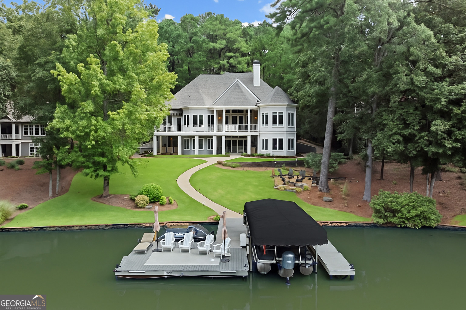 Situated in the desirable Reynolds Lake Oconee community of The Landing, this beautifully updated 6-bedroom, 5-bathroom lakefront home offers an exceptional blend of privacy, luxury, and lake lifestyle. Tucked away on a quiet cul-de-sac and set on a private .81-acre lot, the home enjoys an enviable position on one of the lake's widest and most tranquil coves-with direct access to expansive open water, perfect for boating, swimming, paddleboarding, and sunset views. Spanning three thoughtfully designed levels, the open-concept layout features soaring 25-foot ceilings in the great room, three main-level bedrooms, a massive master closet and a chef-caliber kitchen with high-end custom appliances. Designer finishes-including a richly stained wood ceiling in the dining area-elevate the interiors, while walls of windows frame panoramic lake views from nearly every room. Step outside to effortless lakeside living: a composite Max Dock, 10-person firepit, and lakeside spa make entertaining and relaxation seamless. A practical wet room provides convenient storage for lake gear, ensuring both style and function. Recent updates include a new roof and new boat canopy. Club Membership is available, granting access to Reynolds Lake Oconee's world-class amenities-golf, dining, wellness, and more-making this a rare opportunity to own a premium lakefront home in one of Georgia's most desirable lifestyle communities.