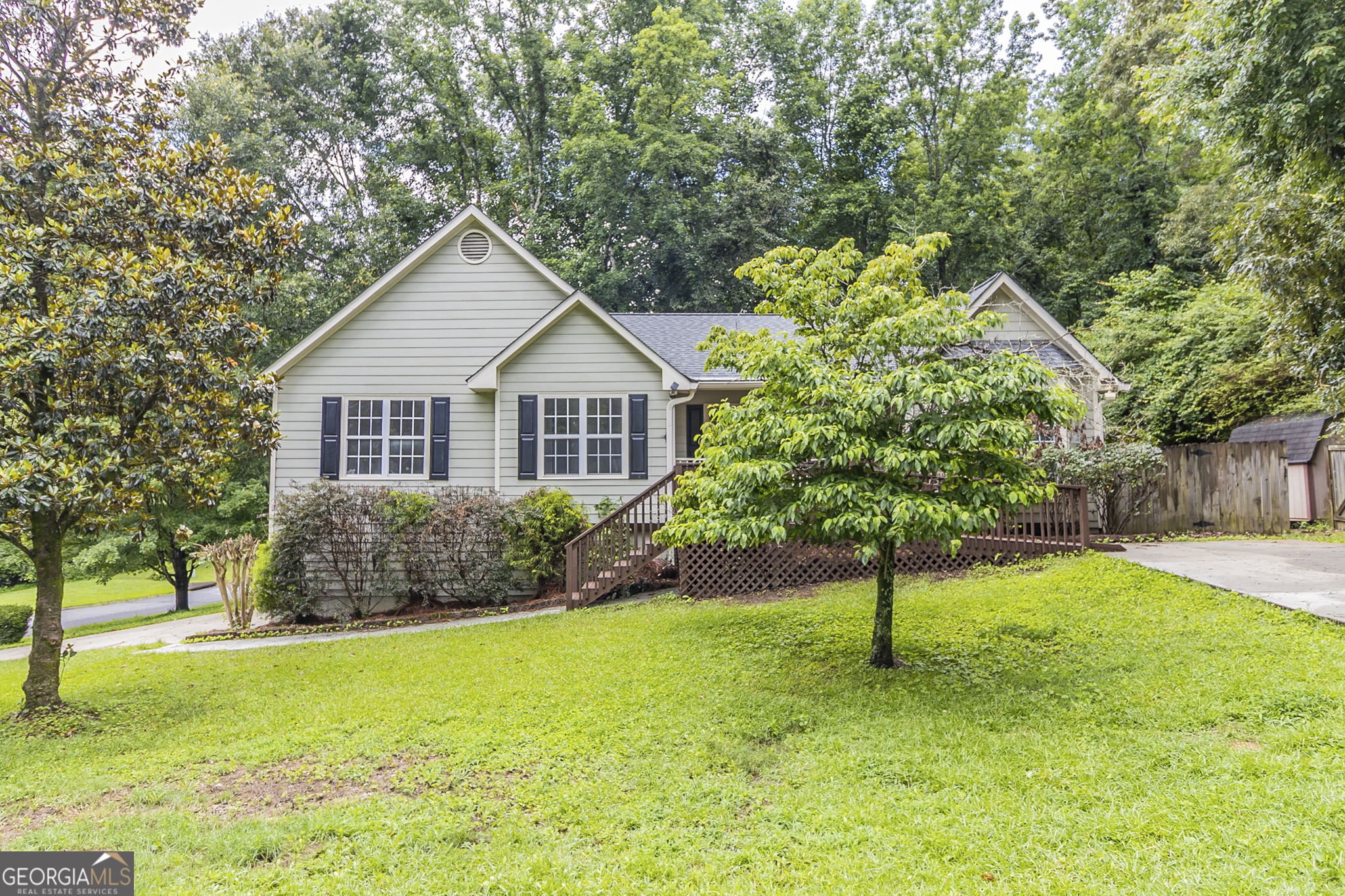 Welcome to this charming 3-bedroom, 2.5-bathroom home situated on a spacious 1/2-acre corner lot just minutes from downtown Acworth, Lake Allatoona, and I-75. Located in a quiet, established neighborhood, this home offers comfort, convenience, and stylish upgrades throughout. Step inside to a bright and open floor plan featuring a vaulted family room with a cozy fireplace, perfect for entertaining or relaxing. The separate dining room provides space for hosting gatherings, while the inviting eat-in kitchen has been recently updated with white cabinetry, new quartz countertops, and brand-new stainless-steel appliances, including a gas range-ideal for home chefs. The primary bedroom features a vaulted ceiling, walk-in closet, and an ensuite bath complete with a soaking tub and separate shower. Two additional guest bedrooms share a full bath, offering plenty of space for family or guests. Downstairs, the finished partial basement includes a built-in bar, a half bath, and flexible space that could serve as a rec room, media area, or home office. Enjoy outdoor living with a large deck that overlooks the fenced-in backyard, perfect for pets, play, or entertaining. A shed provides additional storage, and a separate driveway ensures easy access and ample parking for guests or extra vehicles. Recent upgrades include fresh interior paint, new luxury vinyl plank flooring, and new carpet throughout, making this home truly move-in ready. Don't miss this fantastic opportunity to own a home close to parks, shopping, dining, and all the recreational fun of Lake Allatoona! Some photos have been virtually staged.