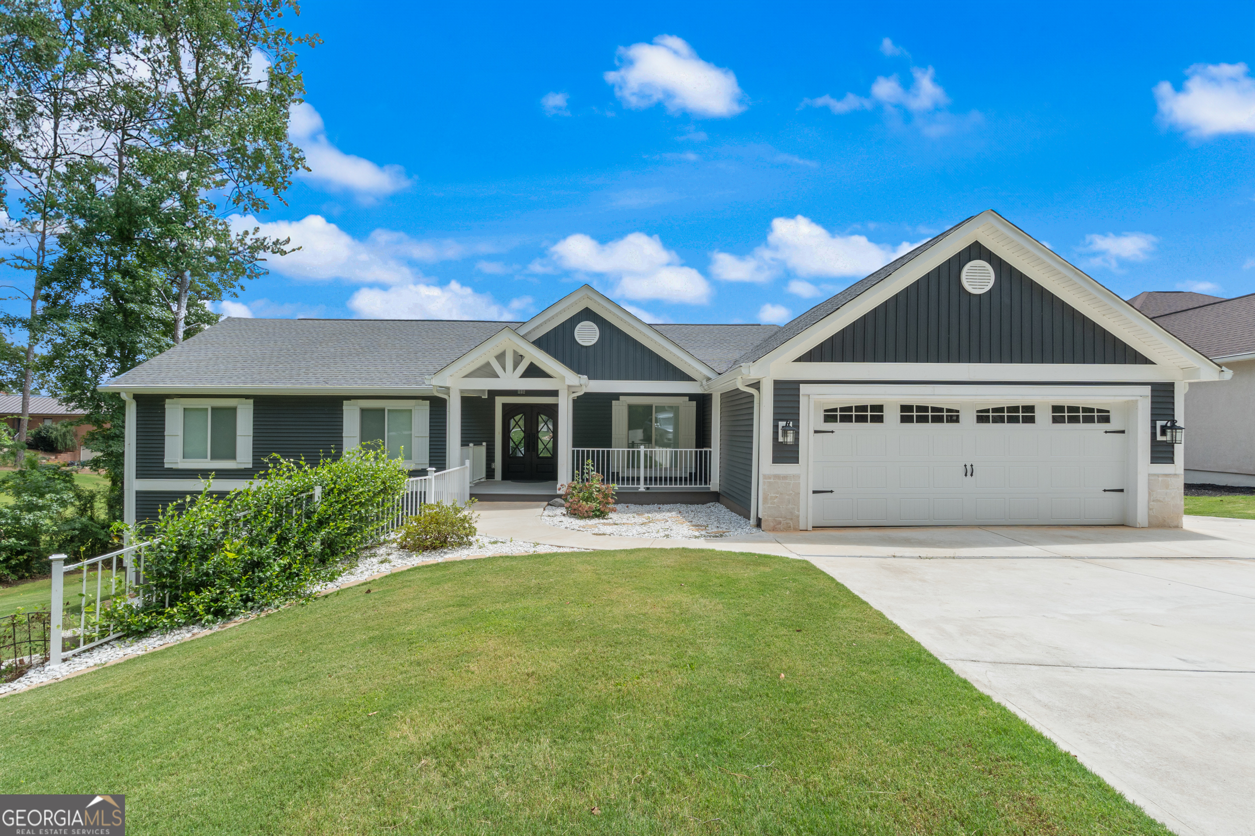 Fully Renovated Lake Home in Gated Community with Resort-Style Amenities. Welcome to this virtually new custom home in one of Villa Rica's premier gated lake communities. Completely remodeled and expanded in 2023, this lakeside retreat offers 3,500+ sq ft of refined living space with 200 feet of direct lake frontage and meticulously designed upgrades and features, inside and out. Step inside to discover an open, light-filled layout with luxurious primary suite, four full bathrooms, and all bedrooms on the main level with a split bedroom floor plan. The designer kitchen is a showstopper, featuring an oversized island, quartz countertops, soft-close custom cabinetry, Cafe appliances, a dual-fuel range, wine cooler, and a walk-in pantry. Vaulted ceilings, oak hardwood floors, and a tongue-and-groove wood ceiling add warmth and charm throughout. The main suite offers serene lake views, a spacious sitting area, a spa-like bath with heated floors, a jetted tub, and a tiled shower. Enjoy year-round outdoor living in the EZ Breeze enclosed sunroom, on the composite deck with glass baluster railings, or the covered patio below-just steps from your private dock. The finished walkout lower level includes a full bath, kitchenette/wet bar, and a wall of windows that floods the space with light. Additional Highlights include, Brand new siding, windows, doors & roofline, Andersen maintenance-free windows & skylights, Custom iron and glass details throughout, New 3-zone Carrier HVAC & ductwork, Tankless water heater & total-house water filtration, Fireplace with rock surround & antique oak mantle, Heated crawlspaces with concrete flooring for ample storage, New dock with electric boat lift and 200' concrete seawall, Buried propane tank (gas stove, fireplace, on-demand hot water),Fully upgraded drainage, landscaping, driveway & hardscape. All within a secure community with access to boating, fishing, golfing, tennis and other recreational amenities. Whether you're looking for a full-time residence or a luxury retreat, 2387 Battle Dr. delivers on every level. Truly turnkey and built for comfort, function, and low maintenance-This home offers lake life without compromise. Schedule your private tour today to experience the beauty and quality firsthand!
