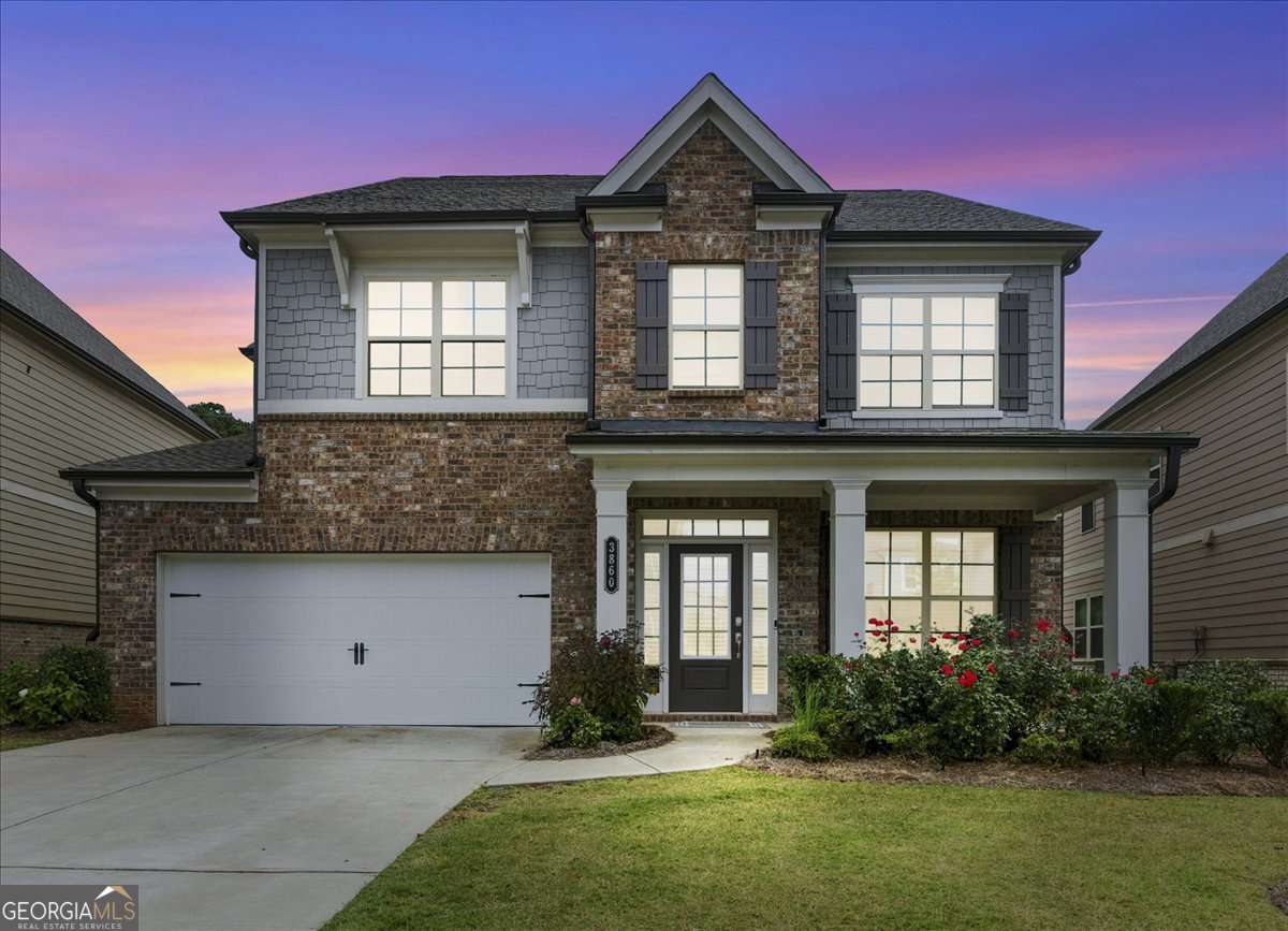 Built in 2021, this stylish north facing home in the Traditions community offers a perfect blend of comfort, design, and convenience. From the moment you step inside, the light-filled interiors and open concept design set the tone for easy living and effortless entertaining. Wide plank hardwood floors and ten foot ceilings create a sense of space, while a wall of windows brings in natural light throughout the main level. At the center of the home, the kitchen impresses with white cabinetry, granite counters, and a large island that doubles as both prep space and gathering spot. Premium appliances, including double ovens, a gas cooktop, microwave, and refrigerator, add both function and style. The adjoining family room with its gas fireplace provides a cozy backdrop for relaxing evenings, and a walk-in pantry keeps everything organized. The main level also includes a private guest suite with a full bath, while the upper floor is anchored by a spacious primary suite featuring a spa inspired bath and walk-in closet. Two additional bedrooms, a well appointed hall bath, and a flexible loft give everyone room to spread out. The laundry room is also located upstairs for convenience. Outdoor living spaces include a covered front porch perfect for morning coffee and a grilling patio that opens to a private, level backyard. Traditions residents enjoy resort style amenities, including an Olympic size pool with lake views, tennis and pickleball courts, fitness center, clubhouse, playground, and direct access to the Greenway trail. The location is ideal, just minutes to GA 400, The Collection, Halcyon, and Vickery Village, with top rated Forsyth County schools: New Hope Elementary, DeSana Middle, and Denmark High.