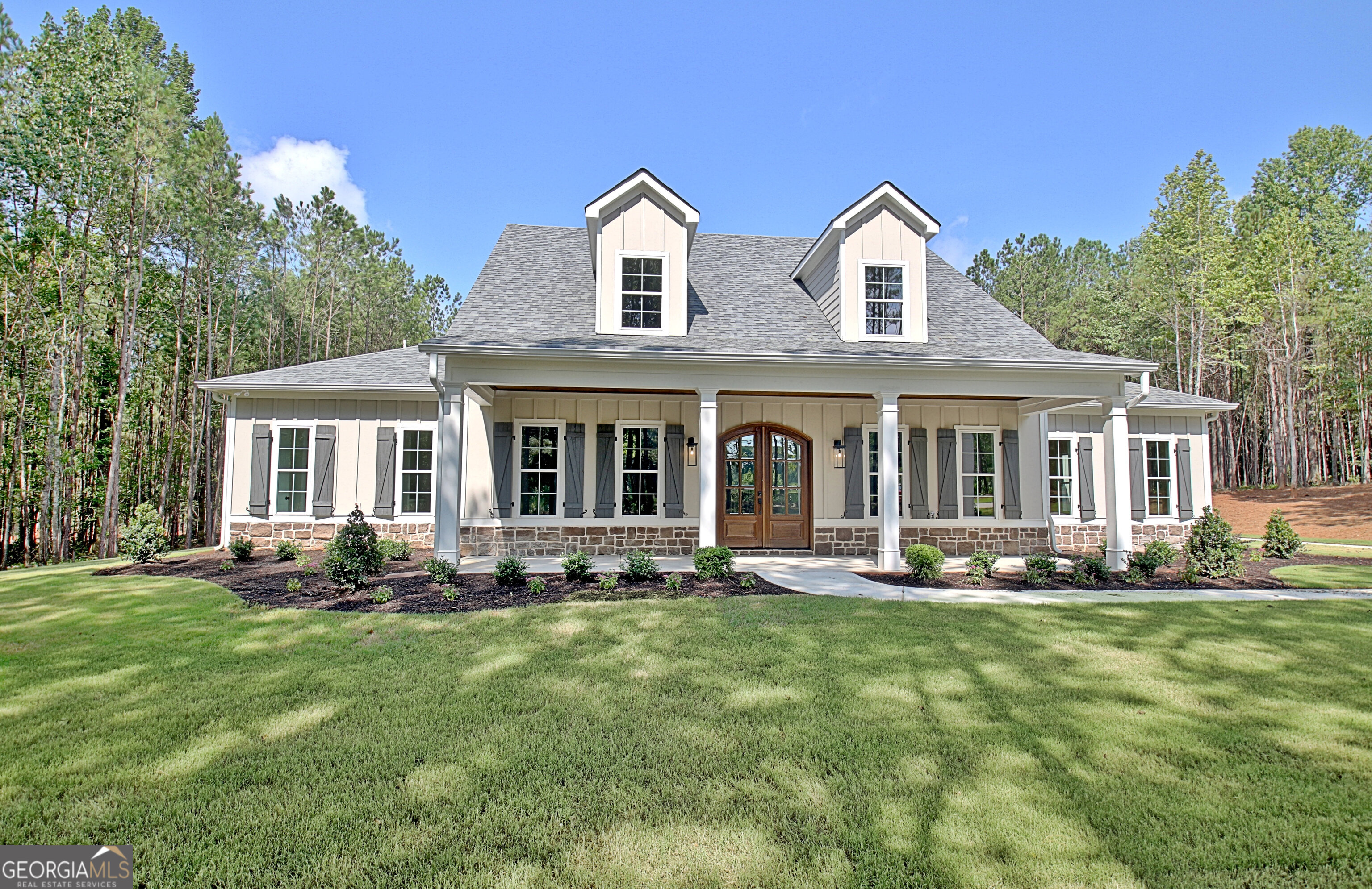 Mitch Ginns' Tallaway Plan boasts an open-concept floor plan ideal for entertaining, featuring a seamless flow from the kitchen to the oversized, vaulted family room and keeping room, both with fireplaces. Situated on a 3-acre lot in Sharpsburg, GA, this residence offers a main floor primary suite complete with an oversized master closet, his/her vanities, a freestanding tub, and tile shower. A generously sized laundry room and mud room are thoughtfully located near the primary suite and 3 car garage. The kitchen features a large island with seating, walk-in pantry, SS appliances, and custom cabinetry. Two additional bedrooms with private ensuite, and walk in closets are on the main level as well. The second floor boasts the 4th bedroom, and full bathroom. Outdoor living is enhanced by a large, vaulted back porch and a rocking chair front porch. Additional custom features include hardwood floors throughout, spray foam insulation, tiled wet areas, custom closet systems in the primary closet and pantry, 4-sides irrigation, central vacuum, and tankless water heater.
