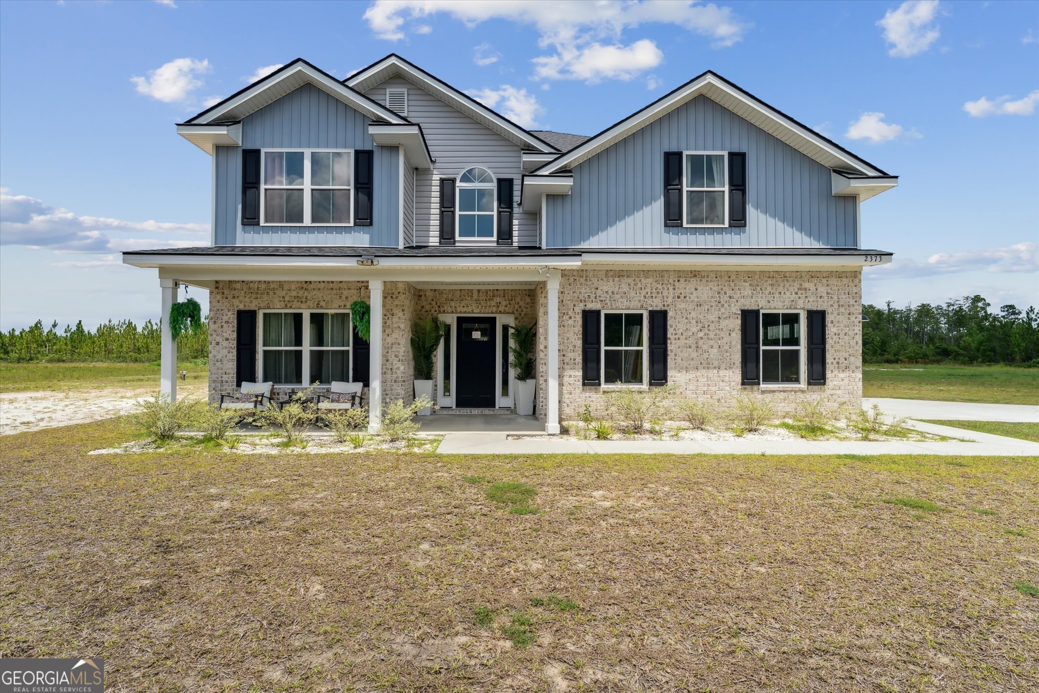 This stunning 5-bedroom, 3-bathroom home in Ludowici sits on 1.80 acres and looks like it came straight out of a showroom! Thoughtfully designed with a spacious open floor plan, it features a formal dining room, a bedroom and full bathroom on the main level, and a small loft upstairs overlooking the two-story foyer. From bedroom closets to hall storage, there's no shortage of space for all your essentials. The owner's suite is a true retreat with a private sitting area, built-in wall shelves, an en suite bathroom with a soaking tub and walk-in shower, plus a large walk-in closet complete with a vanity and custom closet system. Step outside to the backyard with a covered patio and playset, ideal for entertaining or relaxing. The yard also extends into the trees, offering even more space to use as you desire. From top to bottom, this home is immaculate-schedule your showing today and see for yourself!