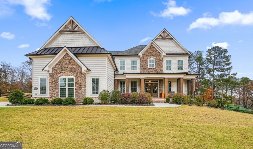 Experience elevated living in this stunning 5 bedroom, 4 bath craftsman style residence located in the prestigious Milton Overlook community. Built in 2021, this home combines refined craftsmanship with modern sophistication, offering a thoughtful blend of style, comfort, and functionality, all just moments from the Milton line. From the moment you arrive, the stone accented exterior, cedar beamed covered front porch, and beamed eaves create exceptional curb appeal. Situated on a spacious .9 acre cul de sac lot, the property features a long, level driveway leading to a 3 car side entry garage and an expansive yard perfect for outdoor enjoyment. Step through the double front doors into a bright, welcoming foyer adorned with warm hardwood floors and abundant natural light. The main level offers a flexible floor plan including a formal dining room and a private home office or study. The gourmet kitchen is the true centerpiece of the home showcasing custom wood cabinetry, quartz countertops, a large island with seating, stainless steel appliances, a walk in pantry, and a beautifully appointed coffee bar. A butler's pantry connects seamlessly to the dining room, making entertaining effortless. The open concept great room features custom built ins and a striking floor to ceiling stone fireplace, creating a warm and inviting atmosphere for gatherings. A main floor guest suite with a full bath provides privacy for visitors, and a custom mudroom off the garage adds function and organization to everyday living. Upstairs, retreat to the luxurious primary suite with a tray ceiling, sitting area, and a spa inspired bath offering dual vanities, a soaking tub, an oversized walk in shower, and a generous custom closet. Two secondary bedrooms share a Jack and Jill bath, while a fourth bedroom features its own private ensuite, making it perfect for family or guests. A spacious bonus room provides flexibility for a media area, playroom, or office. The partially finished walkout basement extends your living space with a private gym and additional living area, plus ample unfinished space ready for customization whether you envision an in law suite, game room, or home theater. Enjoy the outdoors from the open air deck overlooking the peaceful, tree lined backyard that offers both privacy and beauty. This home truly embodies luxury, comfort, and exclusivity; a rare opportunity in one of Woodstock's most coveted communities, just minutes from Downtown Woodstock, Downtown Canton, top-rated schools, parks, and local dining.  Highlights Include: Built in 2021 with custom design and premium finishes. 5 bedrooms, 4 full baths + bonus room & basement. Chef's kitchen with quartz counters, custom cabinetry & coffee bar. Guest suite on main. Partially finished terrace level with gym & flex space. 3 car side entry garage on a .9 acre cul de sac lot. Convenient to Woodstock, Milton, & Hickory Flat.