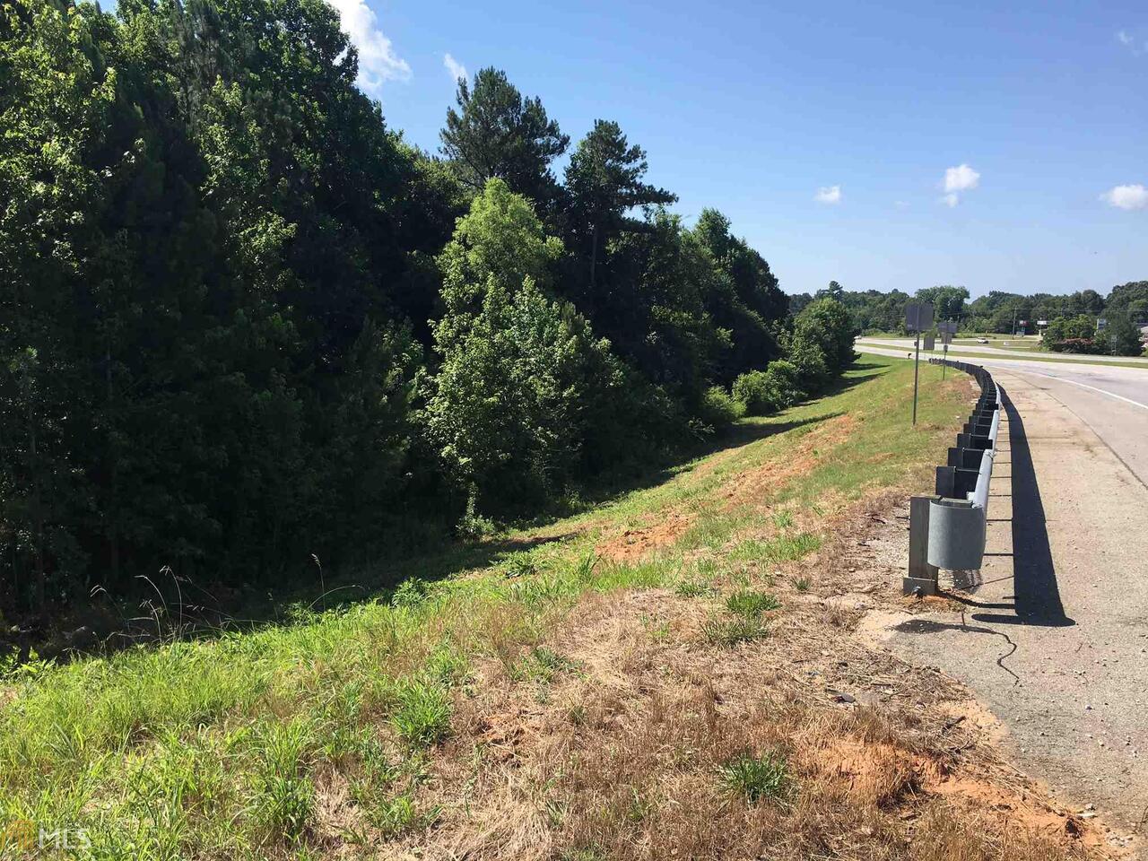 Land For Sale in Roopville, GA on the Carroll-Heard County line. With approximately 350' feet of road frontage on Hwy 27 S this 4+/- acres is conveniently located to Carrollton. The property is classified as R4-Residential and the terrain is favorable for building. The lot consists of a mix of pine and hardwood timber. There are two structures on the property that have no value. The lot is being sold "AS IS".