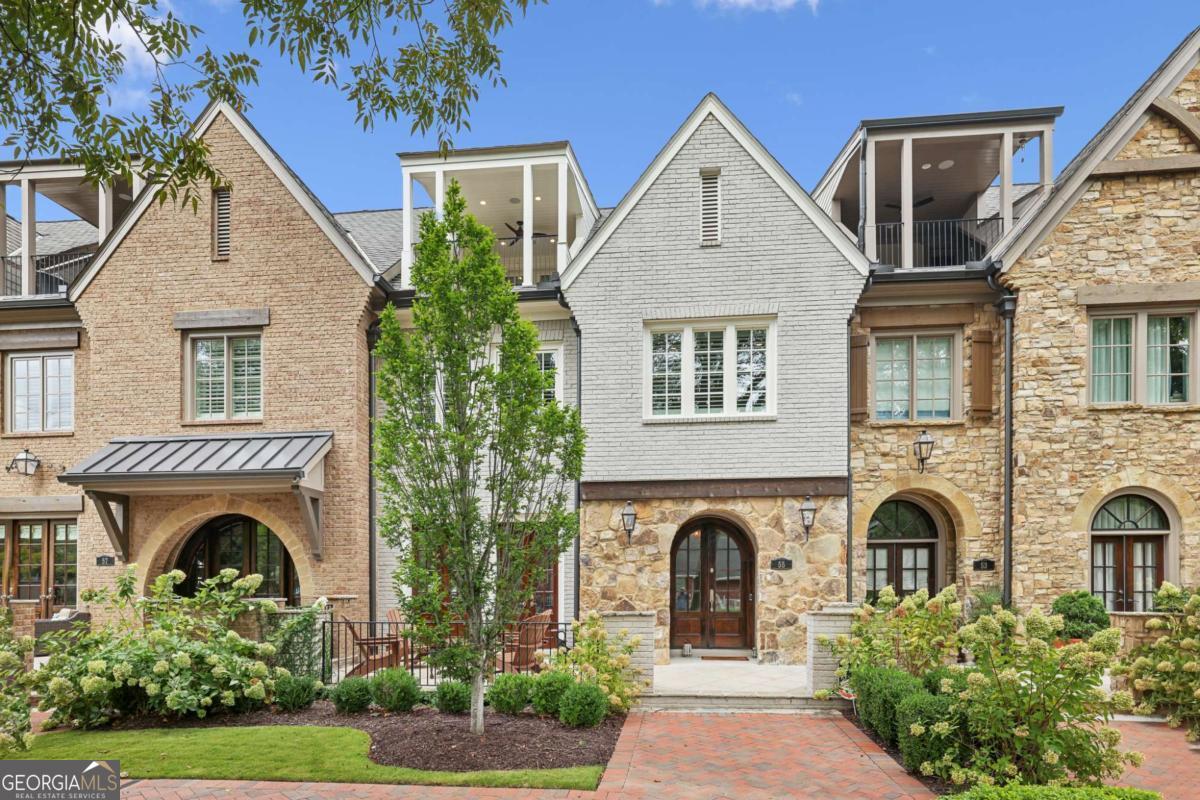 Rare opportunity to live in the heart of downtown Alpharetta. Short walk to everything this wonderful city has to offer. This beautiful brick and stone townhome just off Canton Street welcomes you with an elegant paved courtyard patio. You are welcomed inside the double door entry by 10' ceilings, an open floor plan, and gorgeous hardwood floors. The great room features a statement fireplace with raw timber mantle. Through the dining room you find a gorgeous kitchen with a huge island with breakfast bar, beverage cooler, built-in refrigerator, stainless appliance package and stylish glass tile backsplash. Off the kitchen is a large home manager's office or pantry space, valuable bonus space on the main floor. Taking the elevator to the second floor you find the primary suite with sitting area, plantation shutters allow tons of natural light or complete privacy. The primary closet offers separate cabinet space, a mirrored wall and separate hanging space. the spa like bath has a frameless shower with multiple heads, stylish penny tile floor, dual vanity with separate makeup station. The main laundry is located attached to the primary closet for easy access. Secondary bedrooms on the second and third floor are bath ensuite with the upper bedroom offering an office or flex space. The upper patio, which overlooks downtown Alpharetta, is completely private with its own gas fireplace. Finally the lowest level of the home has a 3 car tandem garage with epoxy floor, storage cabinets and a storage room. Excellent schools Alpharetta E.S. and Hopewell M.S. feed to Cambridge H.S. Convenient to GA 400 at Haynes Bridge.