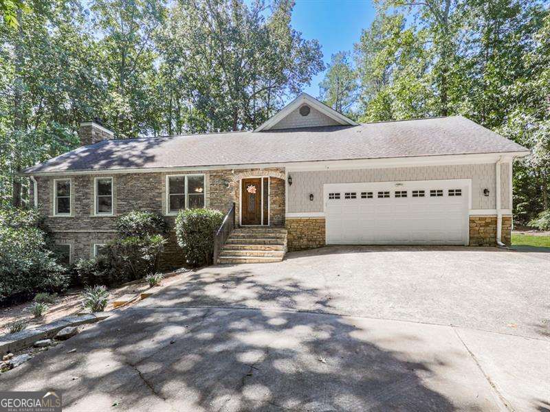 Nestled on over 2 acres of wooded privacy, this solid and inviting home offers the perfect blend of space, charm, and convenience. The open floor plan flows beautifully, starting with a warm and welcoming kitchen featuring solid wood cabinetry, stainless steel appliances, and granite countertops. A huge breakfast/dining room provides plenty of space for gatherings, while the massive family room impresses with its gas log fireplace, soaring vaulted ceilings, and access to a private back deck overlooking the serene setting. Upstairs, you'll find a versatile loft/office and a stunning master retreat with its own private balcony. The spa-like en-suite bath features a clawfoot soaking tub, tiled walk-in shower, and double vanity. Two additional spacious bedrooms are located on the main level along with a covered, screened porch perfect for enjoying the outdoors year-round. The finished basement expands your living options with a large common area, additional bedroom and full bath! Outside, a fenced backyard provides plenty of room to roam, while the long winding driveway crosses a tranquil creek, setting the tone for this peaceful retreat. Located just seconds from Milton, Alpharetta, and Cumming parks, shopping, and activities, this home is a true showstopper-offering the best of privacy, space, and location.
