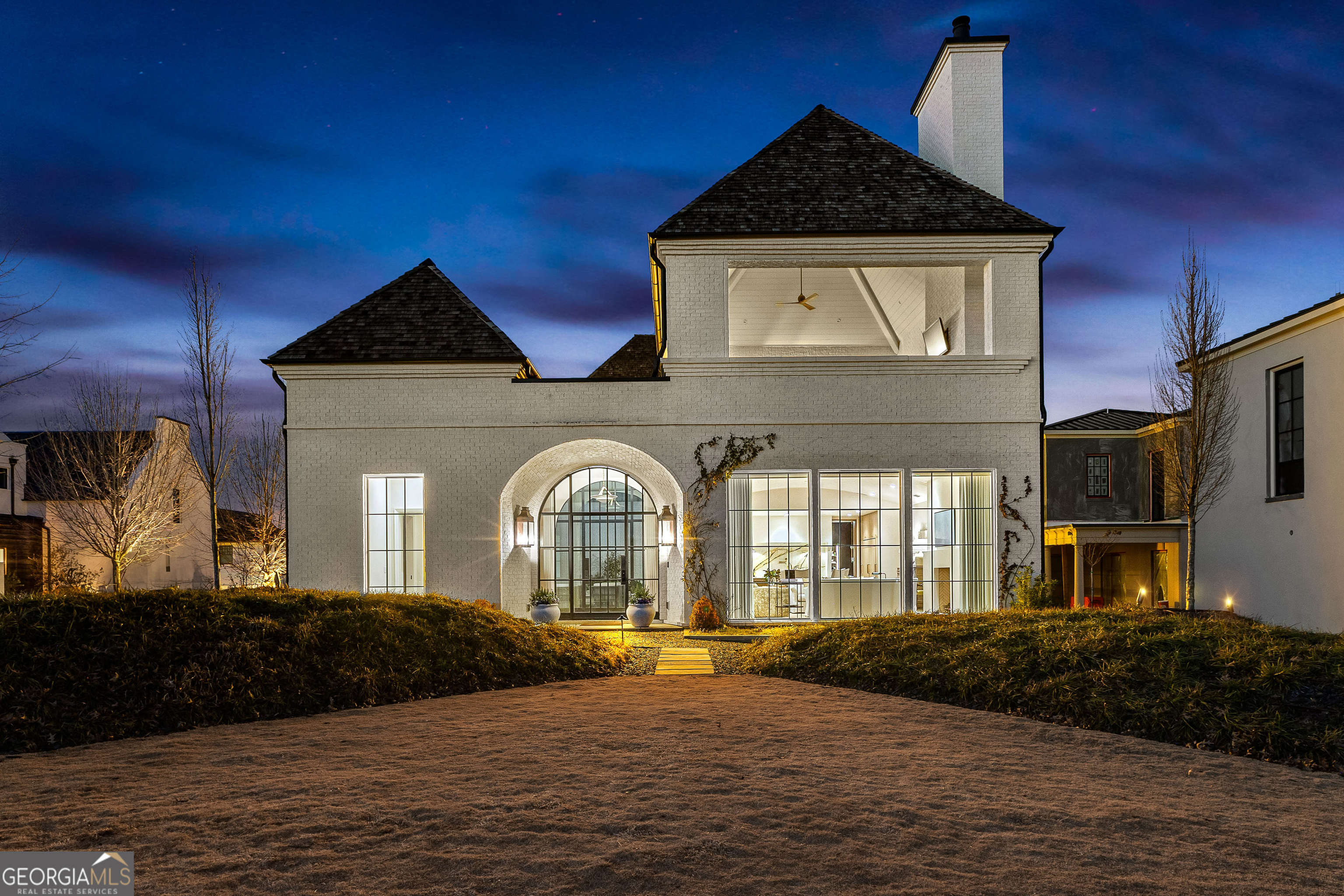 Welcome to a rare and exquisite custom-built luxury home in the vibrant Town of Trilith, where craftsmanship and innovation meet timeless beauty. It is one of only two homes in Trilith constructed by a renowned builder who collaborated with architect, Rudolfo Castro and designer, Anna Booth and allows for a once-in-a-lifetime opportunity to own a piece of perfection. Step into a home that redefines luxury, beginning with oak floors laid throughout, including herringbone patterns in the foyer and in the ADU. The foyer is adorned with custom steel doors at the entry to the home and another at the entry to the outdoor living space. An adjacent powder room features a limestone trough sink imported from France and Italian candelabra sconces. The home boasts plaster walls, adding to its European charm. The open-concept living spaces are breathtaking, with a FireRock masonry fireplace enhanced by cannonballs, oak casings, and sliding pocket doors. The show-stopping barrel ceiling is a work of art, a guaranteed conversation starter. The kitchen is a chef's dream with marble countertops, custom white oak cabinetry, and an exquisite Lacanche range from France. Additional appliances include a Wolf ceiling-mounted vent hood, a Cove dishwasher, and Sub-Zero refrigerators and freezers. Iguzzini lighting over the island provides perfect illumination, while Urban Electric sconces add charm beside the range. The adjacent scullery mirrors the kitchen's luxury with marble finishes, custom cabinetry, and practical elements like a second Sub-Zero refrigerator, an Asko dishwasher, and elegant Zellige clay tile. Glass and brass shelving make it as stunning as it is functional. A bespoke bar with Reeded Radius cabinetry, a Sub-Zero wine chiller, a soapstone countertop with an integrated sink, and a nugget ice maker make the rear hallway another gathering spot for guests. In the same space, an antique Italian chandelier illuminates a curved staircase. The staircase, crafted with rounded plaster walls and custom metal rails, is a focal point of artistry. The primary suite offers another FireRock masonry fireplace, Urban Electric sconces, and a private courtyard. The ensuite bath is a sanctuary, featuring heated shower floors, a Marine speaker, an MTI tub, and oak vanities with marble countertops. The custom-built closet includes hidden luggage storage and direct access to a laundry room equipped with a European heat condensing dryer. The second floor features three additional bedrooms (one is uber special with built in bunks!) and all have en suite baths. This space also provides access to the upper loggia. With its floating teak floor and another FireRock masonry fireplace, this outdoor space offers unmatched views and comfort. A private entrance to the accessory dwelling unit (ADU) offers lock out to the owner's home. With herringbone pine floors, a fully equipped kitchen, washer/dryer, and bathroom, this space has finishes that mimic the main home and provides flexibility for guests or rental income. Step outside to an entertainer's dream. The outdoor kitchen boasts stainless steel cabinets, a 36" Coyote pellet grill, an integrated 2-burner cooktop, and soapstone counters. Blue Ice natural stone tile from India surrounds the stunning plaster pool and hot tub spillover. Smart home features include a state-of-the-art DMSS carrier system, Wi-Fi hubs, a comprehensive alarm system, automated shades and custom window treatments by The Drapery Room, and Lutron lighting controls with dimmers throughout the main floor. Architectural Highlights: Andersen windows and copper lanterns; Elevator-ready shaft; 12+ ft ceilings on the main floor; 10 ft on the second; Custom lighting fixtures and imported materials throughout; Unlaquered brass Waterworks plumbing fixtures. This home is more than a residence; it's an artful retreat. Schedule your private showing today and step into a world of unrivaled luxury.