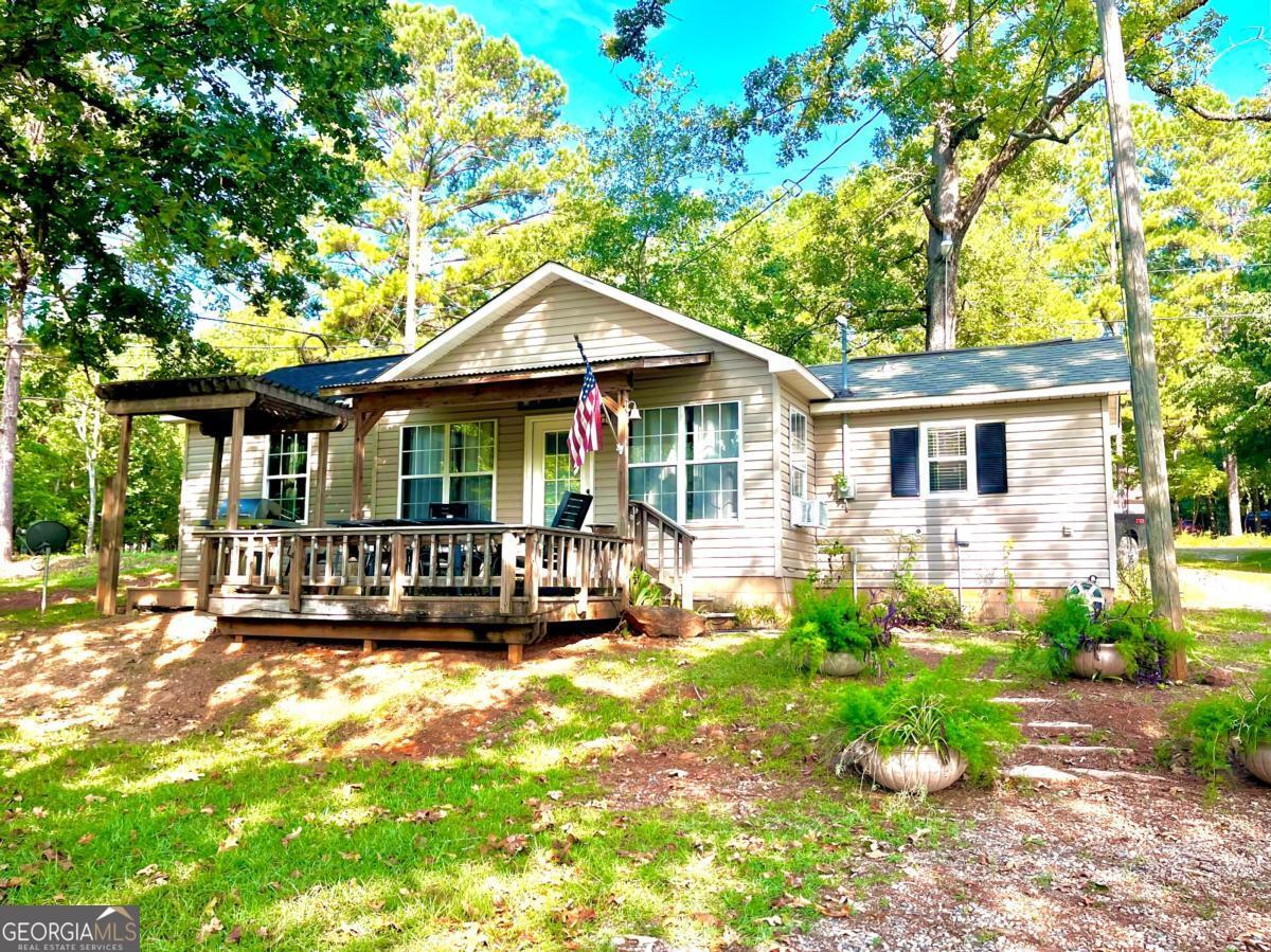 Are you seeking a quaint lake cabin to indulge in the lake's splendor? This large property boast an array of desirable features, including a double slip boat house, sea wall, brick steps leading to the water, and a rare concrete boat ramp. Additionally, the charming cabin features a full bath, an open living/kitchen/dining area with a pull down murphy bed, and a newly finished bedroom addition. Located in the heart of a picturesque cove, this property offers seamless access to the main water without navigating bridges. This property also offers RV Hookups. Contact Melvin "Charles" Tapley for more details at (912) 245-0230