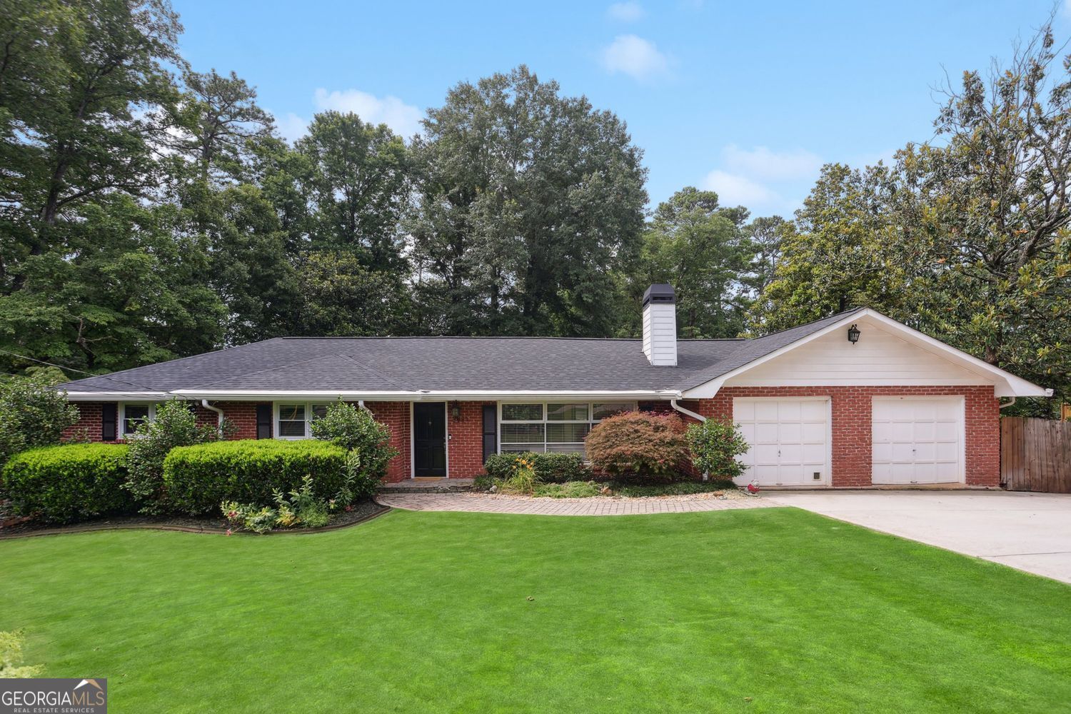 Beautifully updated and meticulously maintained all brick ranch in the heart of Smyrna. Nestled on half an acre, this home offers 4 bedrooms and 3 full baths across a spacious layout with tons of charm throughout! Updated kitchen with tile backsplash, recessed lighting, a breakfast bar, a newer refrigerator, and newer appliances including a new dishwasher and microwave. Impressive owner's suite features a private deck overlooking a gorgeous, landscaped backyard. Generous master bath with double vanity, jetted tub, separate water closet, frameless shower and built in walk in closet. Hardwood floors and fresh interior paint throughout the main level. Just off the kitchen, the cozy family room flows seamlessly to a screened-in porch and extended deck-perfect for entertaining or relaxing outdoors! Step outside to your fenced-in backyard retreat featuring a koi ponds, fire pit, patio and storage shed. Kids and kids-at-heart will love the zip line, rope swing, teeter totter, balance beam, trampoline, and climbing dome. Additional updates include a 3-year-old roof, newer water heater, and newer driveway. Full daylight basement features guest/in-law suite, full bathroom and recreational space. Enjoy unbeatable convenience with quick access to The Battery Atlanta, Truist Park, Smyrna Market Village, Vinings Jubilee, the Silver Comet Trail, and more. This home truly offers the perfect blend of modern comfort, classic charm, and proximity to dining, shopping, I-285/I-75 and entertainment!