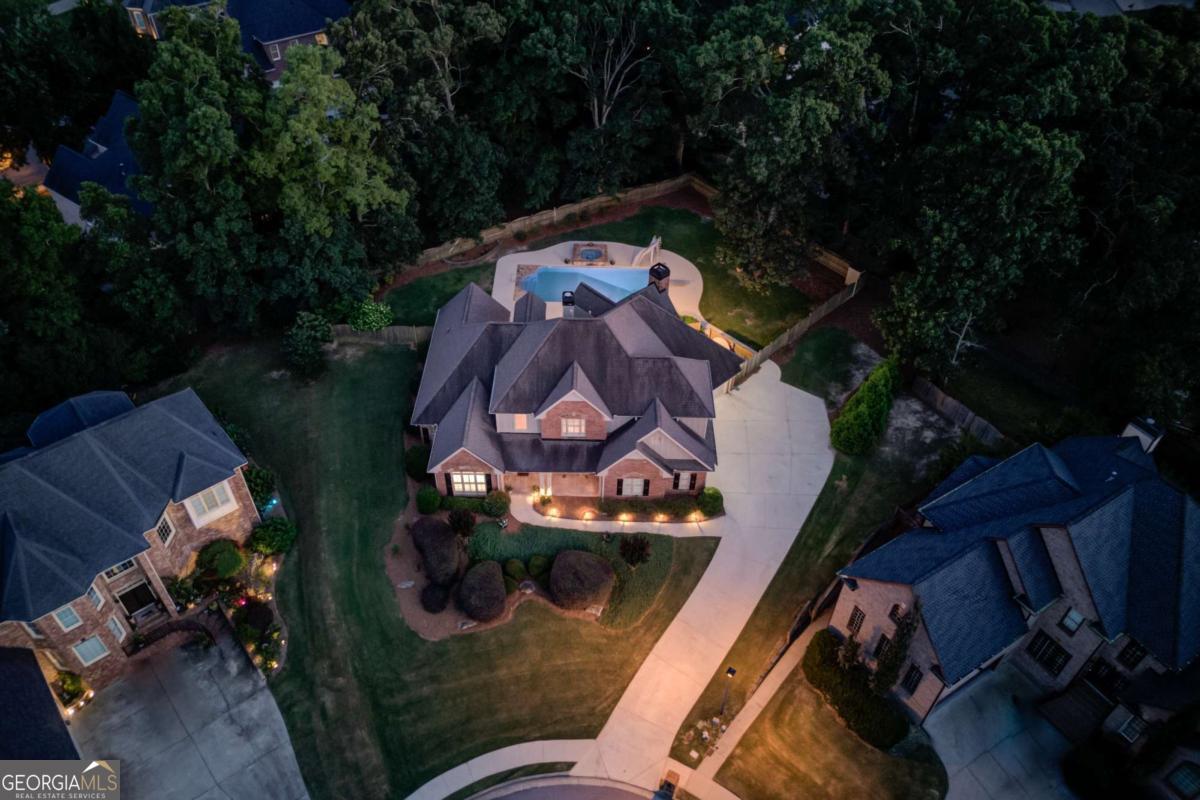 HEATED SALTWATER POOL & SPA! ENTIRE INTERIOR HAS RECENTLY BEEN PAINTED "City Loft" by Sherwin Williams AND IS MOVE-IN READY! IMPRESSIVE, 4-SIDED BRICK & STONE ACCENTED, CUSTOM-BUILT, MOVE-IN READY HOME, FEATURING A 3 CAR SIDE GARAGE, A STUNNING GRAND ENTRY & MAIN LIVING SPACE, SOARING CEILINGS THROUGHOUT, AN OPEN CONCEPT FLOOR PLAN, AND A PRIMARY SUITE ON THE MAIN, ALL OVERLOOKING THE BACKYARD OASIS - HEATED SALTWATER POOL & SPA! This stately home is beautifully positioned on an elevated, private, oversized cul-de-sac lot - nearly 1/2 acre, with gorgeous landscaping and hardscape features throughout! Greeted by the beautiful, rocking chair front porch with a stunning DOUBLE DOOR entry, you are welcomed you into a bright, two-story grand open living space with SOARING CEILINGS, wrap around floor to ceiling windows showcasing the amazing RESORT STYLE backyard, PLANTATION SHUTTERS, NEW FLOORING, and a beautiful WOODEN staircase with wrought iron balusters - quite the first impression! The GOURMET KITCHEN features stained cabinetry, a gas cooktop, double ovens, stainless steel appliances, granite countertops, a tiled backsplash, and a center island. The keeping room is framed with elegant FLOOR TO CEILING columns that highlight the vaulted ceiling with EXPOSED BEAMS and a stunning stone fireplace - perfect for relaxation! The main level primary suite features a beautifully trimmed trey ceiling, a large, updated bathroom with a high, accented vaulted ceiling and chandelier that highlight the tub area, and a tiled shower. An additional office/flex area is also on the main floor with a double french door entry, an oversized window, and a vaulted ceiling. The second floor features a loft/office space with built-ins overlooking the main living area and three additional bedrooms. The private, fully fenced, BACKYARD PARADISE is ready for year-round entertaining and relaxation - a large patio area featuring an OUTDOOR KITCHEN space with a built-in Bull Grill, a heated saltwater swimming pool and stone accented spa with a WATER SPILLOVER, a NEW automated pool cover, a NEW PUMP, a DIVING BOARD and a SLIDE! The swimming pool and spa have been meticulously maintained, with a new liner, new pump/filter equipment, and new multi-colored Pentair lighting for those evening swims! Home has an irrigation system, HVAC system is one year old on the main floor and a Rheem tankless water heater (3 years old). Located just minutes to Downtown Buford, the Mall of GA, I-85, and within the new SECKINGER HIGH SCHOOL DISTRICT, you don't want to miss out on this amazing opportunity in the highly sought after ABERRONE COMMUNITY!