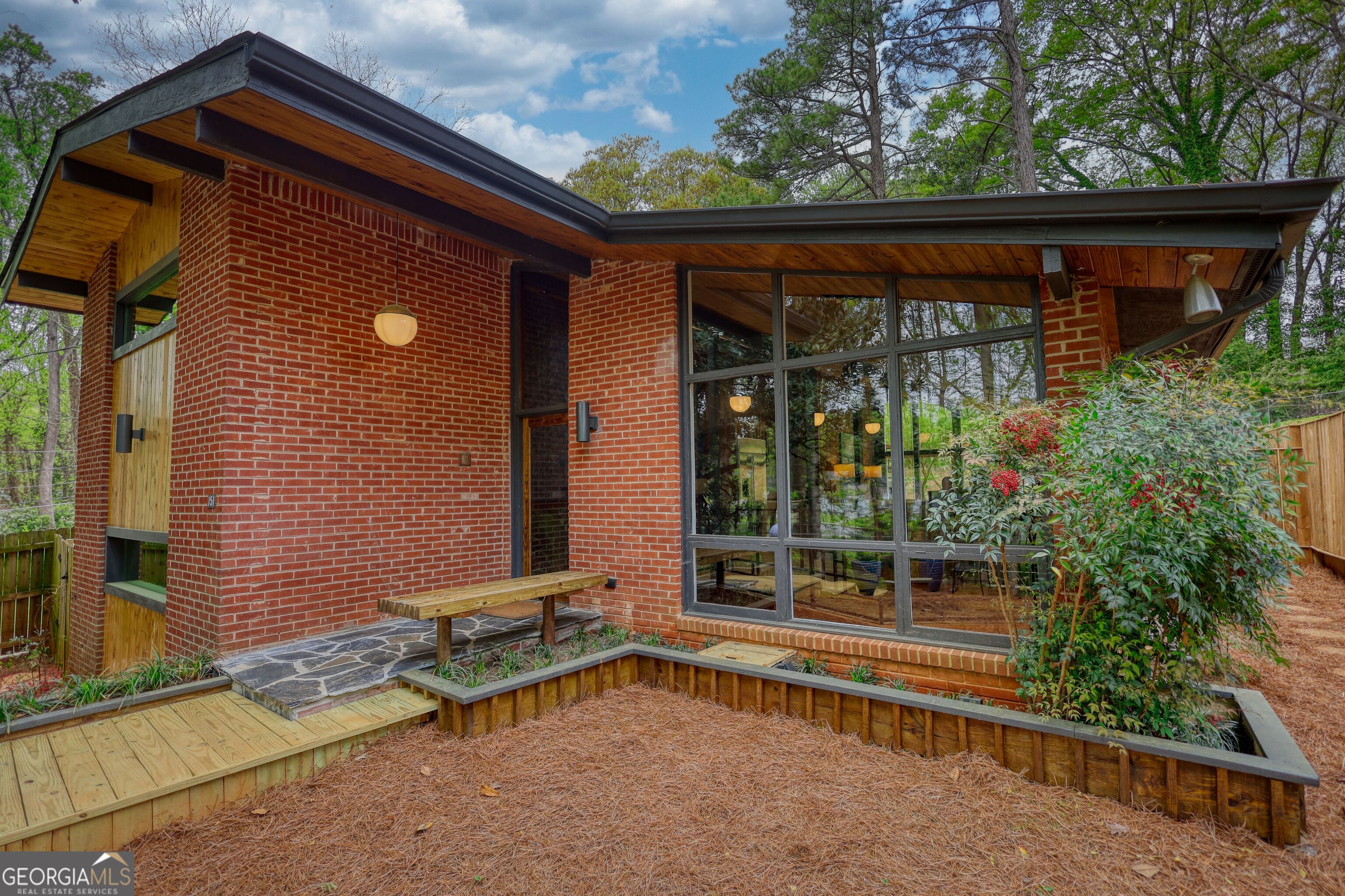 Now is your rare chance to own and live in a genuine piece of art. This caliber of vintage Mid Century Modern home is exceptionally rare. Meticulously restored, it preserves the original vibe and feel while offering all the luxury and amenities you would expect from an upscale home today. Its location can't be beat. It's situated in Historic Mozley Park, which was voted Neighborhood of the Year in 2021 by Urbanized. With 4 Beltline entrances, it's within walking distance to the West End and the Lee and White entertainment district. This MCM home is only a mile and a half from the Mercedes Benz and State Farm arenas, as well as downtown Atlanta. You'll be just minutes from the diverse shops and restaurants in West Midtown. Nestled on a tranquil cul-de-sac, the property faces Proctor Creek and is adjacent to a newly acquired nature preserve park by the city of Atlanta's parks and recreation department. Picture having a green space right across the street. This charming Mid-Century Modern Home offers 4 bedrooms and 3 stunning bathrooms, all as wonderful as the primary. It covers 4 split levels with brief floating stairs. The entrance level invites you to an open concept living room, family and dining room, and a kitchen with a large waterfall-edged countertop island in exotic stone with a leathered finish. Walls of floor-to-ceiling glass overlooking the outdoor areas and nature conspire perfectly for hosting large gatherings and entertaining your friends and family. The light-filled lower level opens to the above balcony and features a lounge/media area that includes a floating bar with a built-in refrigerator/ice machine. The upper level features two spacious bedroom suites, each with attached bathrooms. One of these is the primary suite, which includes its own outdoor room overlooking the tranquil backyard. The final level has two more bedrooms, one with an attached bathroom and the other with its own private covered porch area. This charming home boasts a range of delightful vintage modern features, including stunning floating stairs, an abundance of skylights, and lovely indoor/ outdoor planters. You'll also find a built-in indoor water feature, inviting exposed wood beam vaulted ceilings, and warm tongue and groove walls. There are several cozy outdoor spaces with covered porches and patios, perfect for entertaining, as well as privacy fences and beautiful custom lighting both inside and out. Don't miss the chance to explore this spectacular masterpiece, gracefully perched atop a hill, offering you seasonal views of the Atlanta skyline peeking through the trees!