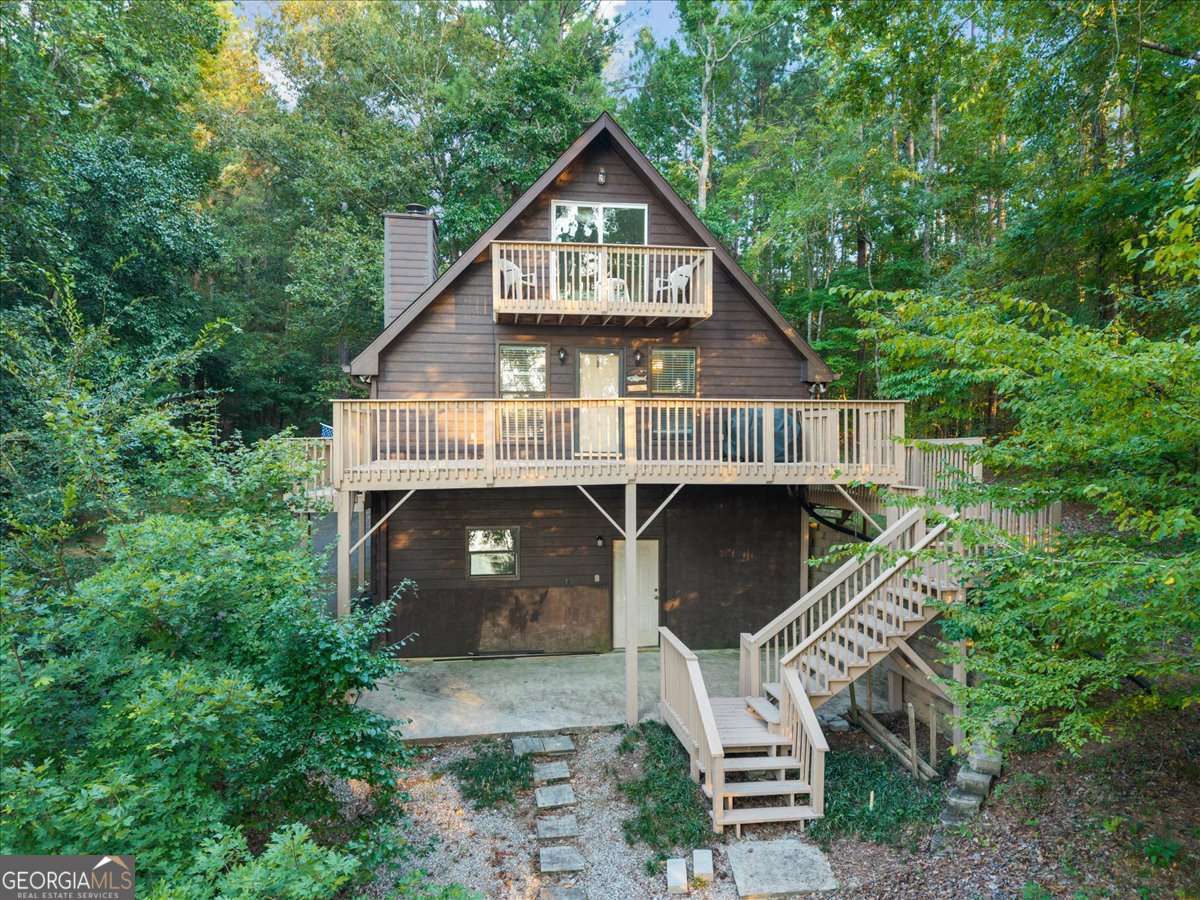 The Classic A frame in the woods, on over 100' of shoreline and the treat of an incredible sunset every evening. This cabin offers the privacy and fun that make being at the lake exactly where you want to be. Holiday Shores offers some great amenities, like a neighborhood boat launch, clubhouse, pavillion and Pickleball courts. Its a friendly neighborhood with lots of social events (see the recent Jet Ski Dock Poker tournament) and a great mix of full time and part time owners. The large deck has just been restained and is ready to be the center of the social scene for you and your friends. The freshly painted interior, new windows, and recent HVAC replacement mean you have a blank canvas to put your personal touch on this home, or ignore it and go out and play! All furniture and furnishings in the home to remain (except bed in upstairs lake side BR) so you won't have to go get new furniture to enjoy your new fun pad. The enormous drive under basement is plenty of space to store all of your toys. The feeling of being in the woods and having the occasional bonfire will make you want to pick up the guitar. Come out and take a look. We bet you'll never want to leave.