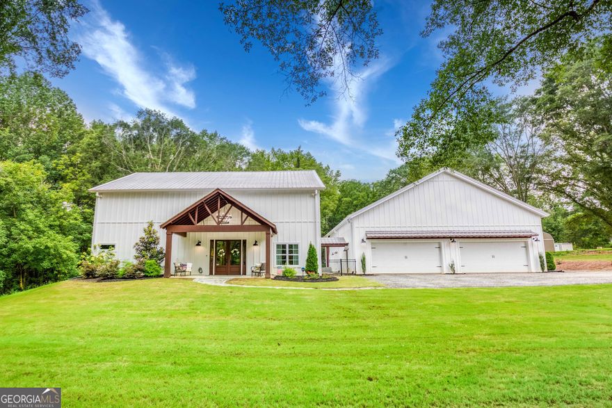 Welcome to your dream barndominium retreat in highly sought-after Oconee County! Situated on 4.38 serene acres, this stunning custom-built 3 bedroom, 4.5 bathroom home offers the perfect blend of rustic charm & modern luxury. Built in 2022- everything is basically brand new! The main home features 3,097 sqft of living space, a covered back deck, and an open-concept layout designed for comfortable living & entertaining. The upper level includes 2 bedrooms with ensuite bathrooms, a loft/office area & the potential for expansion- ideal for additional bedrooms or bonus space. Connected by a breezeway, the massive garage of 2,209 sqft is a true showstopper- offering 4+ car parking, a full gym, a full bath, and the potential to add a second story or loft. Step out onto the covered back patio & enjoy peaceful views of your private backyard, perfect for your future pool oasis. Newly added putting green & turf. Whether you're looking for multi-use space, homestead growth potential, own your own business & need extra storage space or just peaceful country living with easy access to Athens & the surrounding areas- this property truly has it all! Amazing Oconee school district & Right around the corner from The Georgia Club!