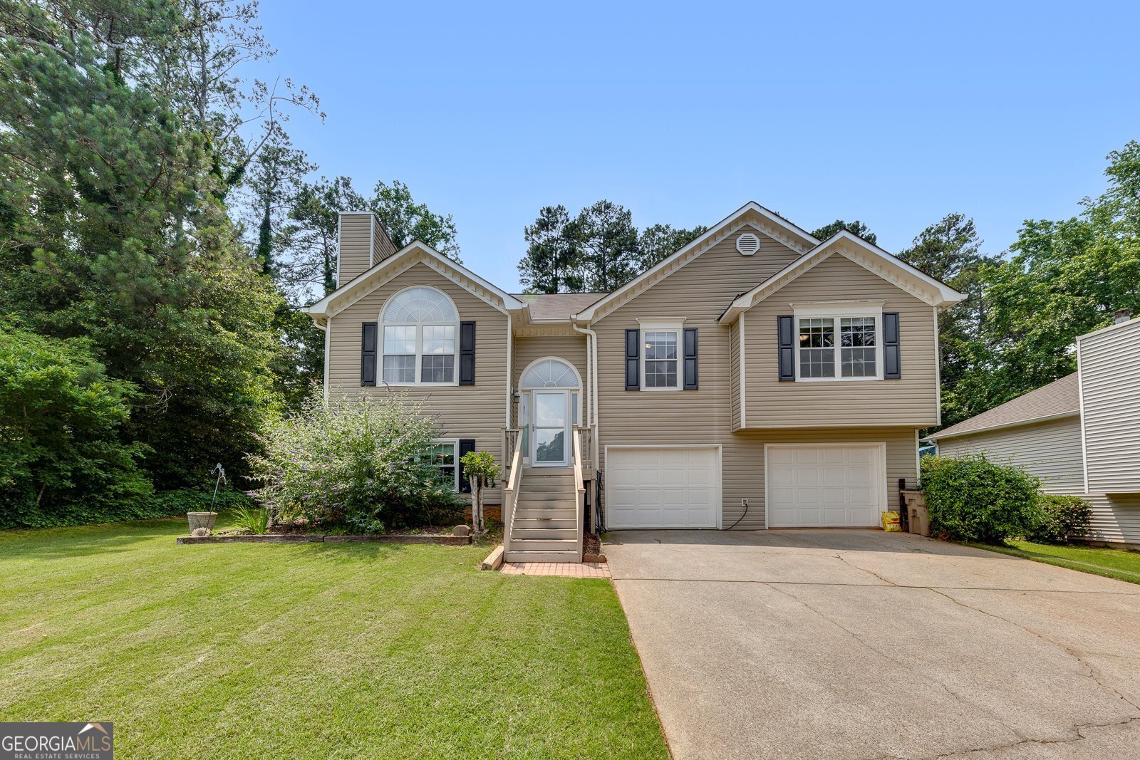 Welcome home to this beautifully maintained 5 bedroom 3 bath home in the much sought after Spicer's Grove Community in Woodstock. Walk in the front door to the split level home with hardwoods throughout the main living space. Main level features an updated kitchen with granite countertops, stainless steel appliances and eat in breakfast area with plenty of natural light. Separate open concept dining room and living room with fireplace. From the dining room step out to the deck, & large fenced in backyard, perfect for entertaining. Primary bedroom on main level features thoughtfully designed tray ceiling, walk in closet, and en suite bathroom with tile flooring, granite countertops, dual vanities, separate shower and soaking tub. Additional 2 bedrooms on main floor and additional full bathroom. Head downstairs to 2 more bedroom spaces, en suite bathroom, and laundry room. A spacious 2 and a half car garage and level driveway complete this beautiful home. Just minutes from restaurants, shopping and award winning schools, this home has everything and all that's missing is you!