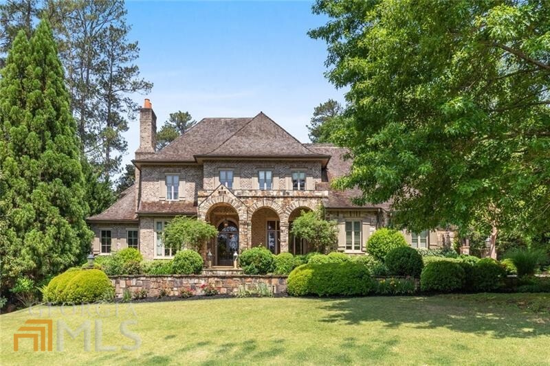 Architecturally designed by renown Spitzmiller Norris this home sits on 1.4+/- acres with mature landscaping. This private retreat is also minutes to Heards Ferry Elementary School and Riverwood Charter High School. This sought after neighborhood is also surrounded by some of the best private schools in Sandy Springs and Buckhead. The curved driveway leads to a three-car side entry garage, porte cochere and additional parking for several guests. Just inside the hospitality door is a drop zone with old brick floors that leads from garage and porte cochere for a daily landing area. Guests are welcomed at the double arched iron front door and covered limestone porch into a magnificent foyer with wide plank hardwood floors. 12 foot ceilings, travertine floors, custom moldings, millwork and archways all create a traditional luxurious warm ambiance. Enjoy the inviting library and office trimmed in maple, adorned with a limestone fireplace and built in bookshelves perfect for bibliophiles. Oversized dining room with French doors that opens to the covered porch extends from butler's pantry pass through with two countertops and abundant cabinetry. Incredible stained glass panel brings additional light into the space. Designer gourmet white kitchen has antique cedar beams, faux venetian plaster and brick accents. Two refrigerators, three dishwashers and copper prep sink. Wolf six burner range and commercial grade hood plus an additional Dacor oven and microwave. Laundry room on main level with pocket doors and plenty of extra storage. Keeping room with view from kitchen has fireplace with brick hearth, exposed antique cedar beams, and opens to a relaxing cedar screened porch with limestone floors and heaters for all season enjoyment. Screened porch has built in grill with dining area plus large seating area for relaxing by the fireplace. Breakfast room overlooks cutting garden with foxgloves. A home office is concealed by pocket doors adjacent to the breakfast room. A refreshment bar is located in between keeping and formal living rooms. Owners retreat has a private hallway, domed ceiling, two water closets, two clothes closets, oversized steam shower, soaking tub, double vanities and dressing area. Enjoy quiet mornings on the covered limestone porch just outside the bedroom door. Terrace level is complete with a home theatre with stadium seating with reclining chairs, temperature controlled wine cellar large enough to hold 1800 bottles, custom imported bar, billiards room, large storage room, guest room with en suite bath and a full gym. Upstairs has second laundry, two generous suites with sitting rooms, en suite bathrooms, walk in closets and home offices/homework hubs flank two other secondary bedrooms with en suite bathrooms plus a fifth room presently used as an office but could be amazing playroom or teen retreat. Swimming pool is 25 x 75 with a raised spa and four fountains at each corner. The pebble tech pool is equipped with fiberoptic lighting and an automatic pool cover. Flagstone with limestone coping showcases the pool deck. Pool house with charming cedar shake roof has a complete serving bar, full bathroom and outdoor shower. Large grassy area beyond pool house. Elevator services all levels. The fourth floor walk up attic level has a cedar closet perfect for off season clothes. Owners installed a commercial grade generator that can power the entire home.