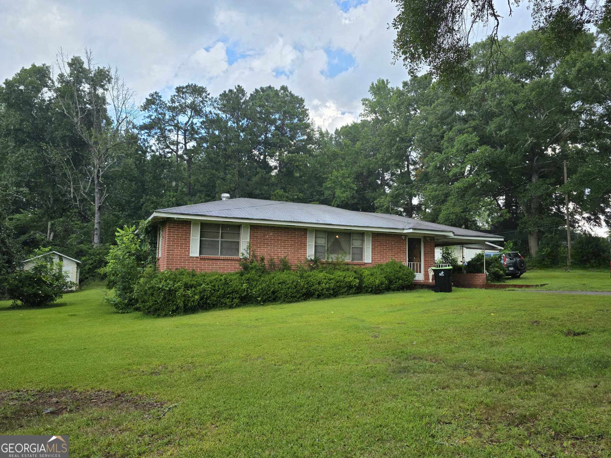 Charming All-Brick Ranch on 1 Acre! This 3-bedroom, 1.5-bath home offers classic comfort and peaceful outdoor living. Step inside to find beautiful hardwood floors, a cozy fireplace, and 1,290 square feet of space. Enjoy your morning coffee or evening breeze on the screened-in back porch, perfect for relaxing or entertaining. The property also features a covered carport and fruit trees, all nestled on a spacious 1-acre lot. With its solid brick construction and inviting charm, this home is ideal for first-time buyers, downsizers, or anyone craving a quiet countryside retreat.