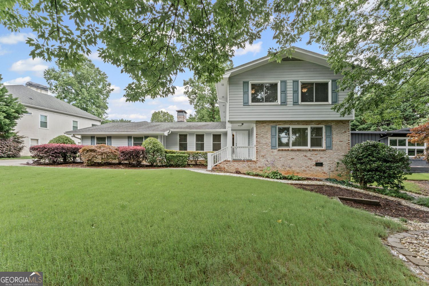 Tucked into one of Dunwoody's most beloved neighborhoods, this 4-bedroom, 3.5-bathroom home blends spacious living, smart function, and touches of charm both inside and out-with energy-efficient upgrades that add even more value and peace of mind. Step through the front door into a main level designed for both comfort and versatility. The heart of the home, the living room welcomes you with vaulted ceilings, a wood-burning fireplace, and warm natural light that spills in from every direction. The updated kitchen-equipped with stainless steel appliances, a wall of pantry cabinetry, and plenty of counter space-opens easily to the living, dining room, and sunroom areas, making this space as practical as it is inviting. Just off the entry and living room, a generous office with built-ins and a double closet offers the perfect work-from-home setup-whether you need quiet focus, ample storage, or a space that can evolve with your needs. Also on the main level, but tucked in the back of the home for privacy, a full bedroom and bathroom create the ideal guest retreat or second primary suite, offering flexibility for multigenerational living. The sunroom is one of those spaces that immediately makes you exhale. Bright and tranquil, it looks out over the backyard and leads directly to the patio. Just off the sunroom is a fully conditioned workout room with its own access to the yard-great for early-morning yoga or sneaking in a quiet moment to yourself. Upstairs, the primary suite feels like a true retreat, featuring two walk-in closets, beautiful natural light, and a spacious en suite with dual vanities, a jetted tub, separate shower, private water closet, and even heated floors for a touch of everyday luxury. Two additional bedrooms share a well-appointed hall bathroom with dual vanity and a tub/shower combo. Throughout the home, hardwood and tile flooring bring style and durability, while plush carpet in the bedrooms adds a cozy touch. Outside, enjoy a terraced backyard with plenty of flat space to play, garden, or relax-surrounded by a bounty of fruit trees and bushes, including blueberries, raspberries, peaches, and figs. Whether you're roasting marshmallows in the landscaped front yard fire pit area or harvesting fruit in the backyard, there's always a reason to be outside. This home isn't just comfortable-it's consciously designed. Solar panels reduce energy costs while helping the environment, and a tankless water heater ensures endless hot water with efficiency. The Tesla Powerwall battery backup provides seamless power during outages, delivering modern peace of mind in a beautifully classic setting. Nestled in a neighborhood loved for its top-rated schools, proximity to interstates, shopping, and dining, and an optional swim/tennis club that brings neighbors together all summer long, this home is more than just a place to live-it's a home designed for living well.