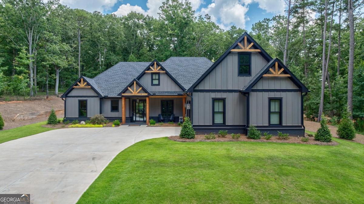 MODERN-RUSTIC CUSTOM HOME IN CUSCOWILLA AT LAKE OCONEE! WELCOME TO THIS BEAUTIFULLY CRAFTED BLEND OF MODERN ELEGANCE AND RUSTIC CHARM, NESTLED IN THE HEART OF LAKE OCONEE'S PRIVATE GOLF COMMUNITY, CUSCOWILLA. CLEAN LINES, NATURAL MATERIALS, AND PURPOSEFUL DESIGN FLOW THROUGHOUT, MAKING THIS HOME AS INVITING AS IT IS STYLISH. A COVERED ENTRY WITH STAINED WOOD POSTS WELCOMES YOU THROUGH A FULL-GLASS, STEEL-FRAMED FRONT DOOR. OPEN-CONCEPT GREAT ROOM FEATURES VAULTED CEILINGS WITH EXPOSED BEAMS AND WARM WOOD PLANK ACCENTS ABOVE THE KITCHEN AND DINING ROOM. CRISP WHITE OAK FLOORS ANCHOR THE SPACE, OPENING INTO THE KITCHEN WITH AN OVERSIZED QUARTZ ISLAND, BLACK CUSTOM CABINETRY, AND STAINLESS APPLIANCES. SPACIOUS CUSTOM PANTRY FOR ADDITIONAL KITCHEN STORAGE. ADJOINING DINING AREA WITH A RICH BLACK TRIM. A SEPARATE VERSATILE ROOM OFF THE ENTRY (EASILY A STUDY, PLAYROOM, OR HOME OFFICE) OFFERS PRIVACY AND FLEXIBILITY. PRIMARY SUITE FEATURES VAULTED CEILINGS, SLIDING BARN DOORS OPENING TO A SPA-INSPIRED EN-SUITE WITH A CLAWFOOT TUB, BLACK-STEEL-FRAMED SHOWER, SHIPLAP ACCENTS, AND A CUSTOM CLOSET. THREE ADDITIONAL WELL-APPOINTED BEDROOMS, EACH REFLECTING THE HOME'S THOUGHTFUL FINISHES-CUSTOM TRIM, HIGH CEILINGS, AND DESIGNER FINISHES. COVERED PATIO WITH MOTORIZED SCREENS EXTENDS THE LIVING SPACE OUTDOORS WITH A CUSTOM HERRINGBONE BRICK FLOOR, VAULTED PINE CEILING, HANGING PORCH SWING, AND AN OVERSIZED CEILING FAN. PROFESSIONALLY LANDSCAPED BACKYARD WITH MATURE HARDWOODS OFFERS BOTH BEAUTY AND PRIVACY, WITH A LEVEL LAWN PERFECT FOR PLAY OR PETS. FULLY FENCED BACKYARD ENCLOSES A FIRE PIT AREA WITH ADIRONDACK SEATING. CAFE STRING LIGHTS AND AMBIENT DESIGN TOUCHES ELEVATE EVERY EVENING GATHERING. THIS BACKYARD DELIVERS BOTH RELAXATION AND ENTERTAINMENT IN A PEACEFUL, SETTING-YOUR OWN RETREAT JUST STEPS FROM YOUR DOOR. LARGE GARAGE INCLUDES SPACE FOR 2 LARGE VEHICLES AND A GOLF CART, EPOXY FLOORING, AND A MINI-SPLIT UNIT FOR HEATING/COOLING. THREE HIGH END HVAC UNITS, GENERATOR, 2 HOT WATER HEATERS, SURROUND SOUND, AND A SECURITY SYSTEM ARE JUST A FEW OF THE ADDED UPGRADES YOU WILL FIND IN THIS HOME. THIS HOME CAPTURES THE HEART OF UPSCALE CONTEMPORARY LIVING-WITH COZY RUSTIC TOUCHES, DESIGNER FINISHES, AND THOUGHTFUL LAYOUT AT EVERY TURN. MOST FURNISHINGS NEGOTIABLE FOR PURCHASE. IN CUSCOWILLA, YOU CAN ENJOY THE CLUBHOUSE RESTAURANT, POOL, GYM, PICKLE BALL, TENNIS, PLAYGROUND, DOG PARK, VEGETABLE GARDEN, AND MORE! CUSCOWILLA GOLF MEMBERSHIP IS AVAILABLE FOR PURCHASE.